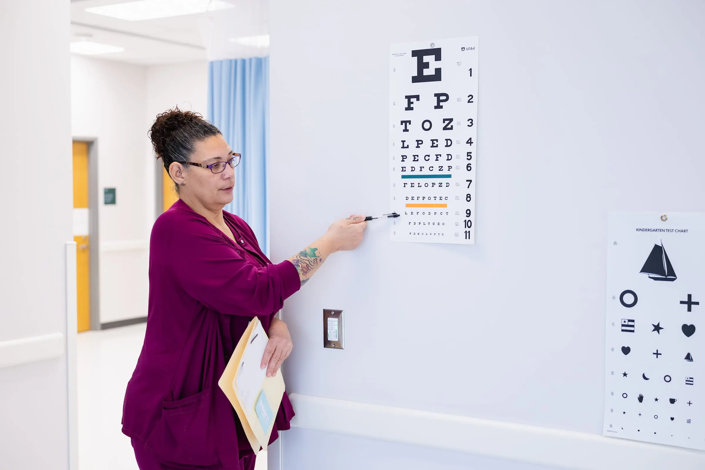 Clinician pointing to a letter on an eye test chart
