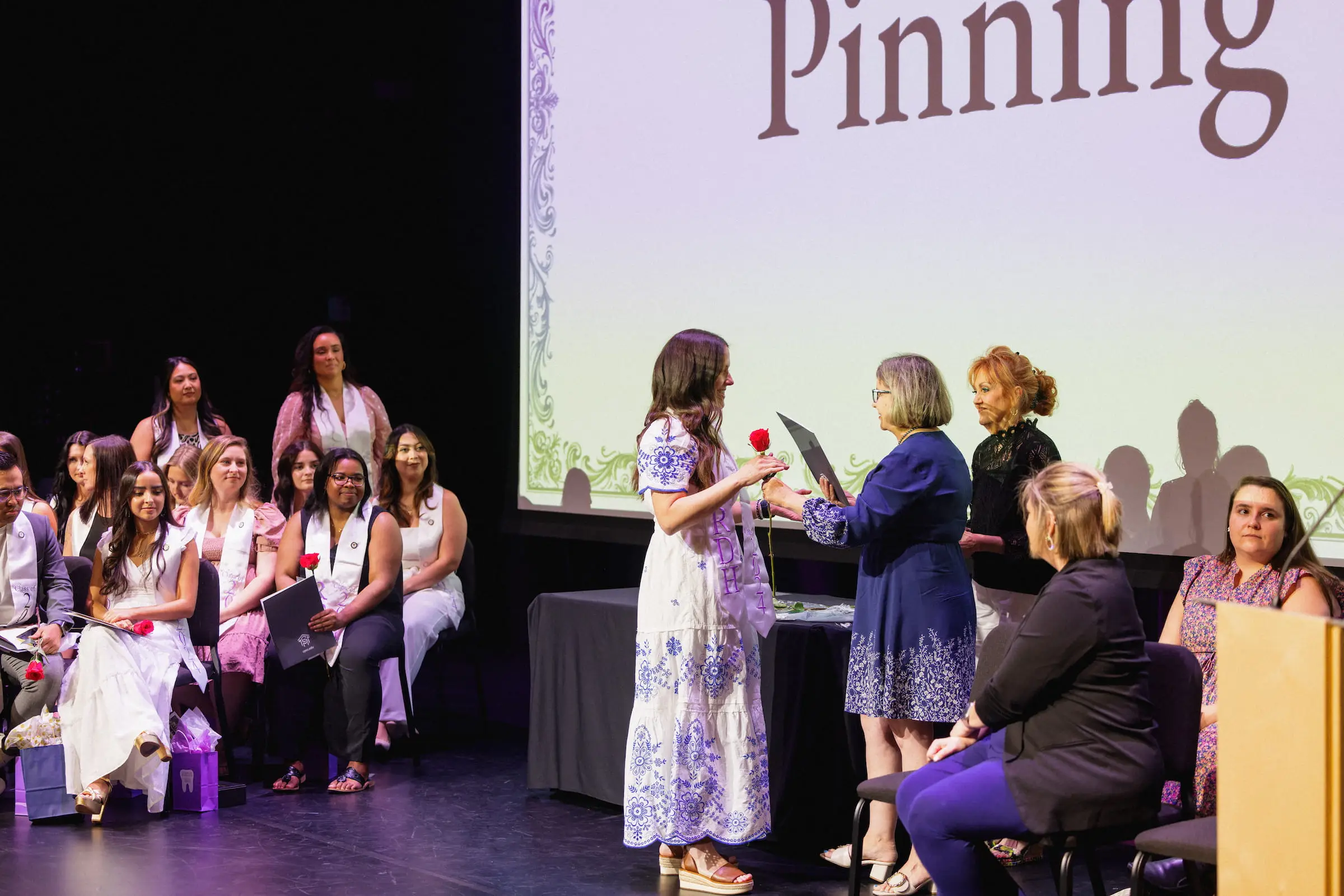Graduate crossing the stage during a pinning ceremony