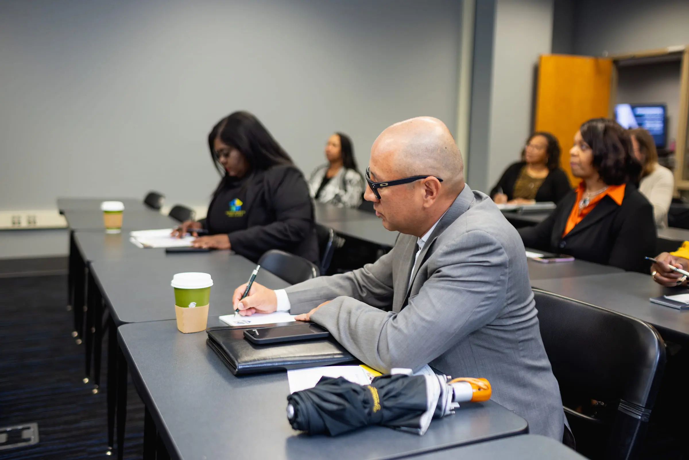 Participants taking notes during a caseworker training session