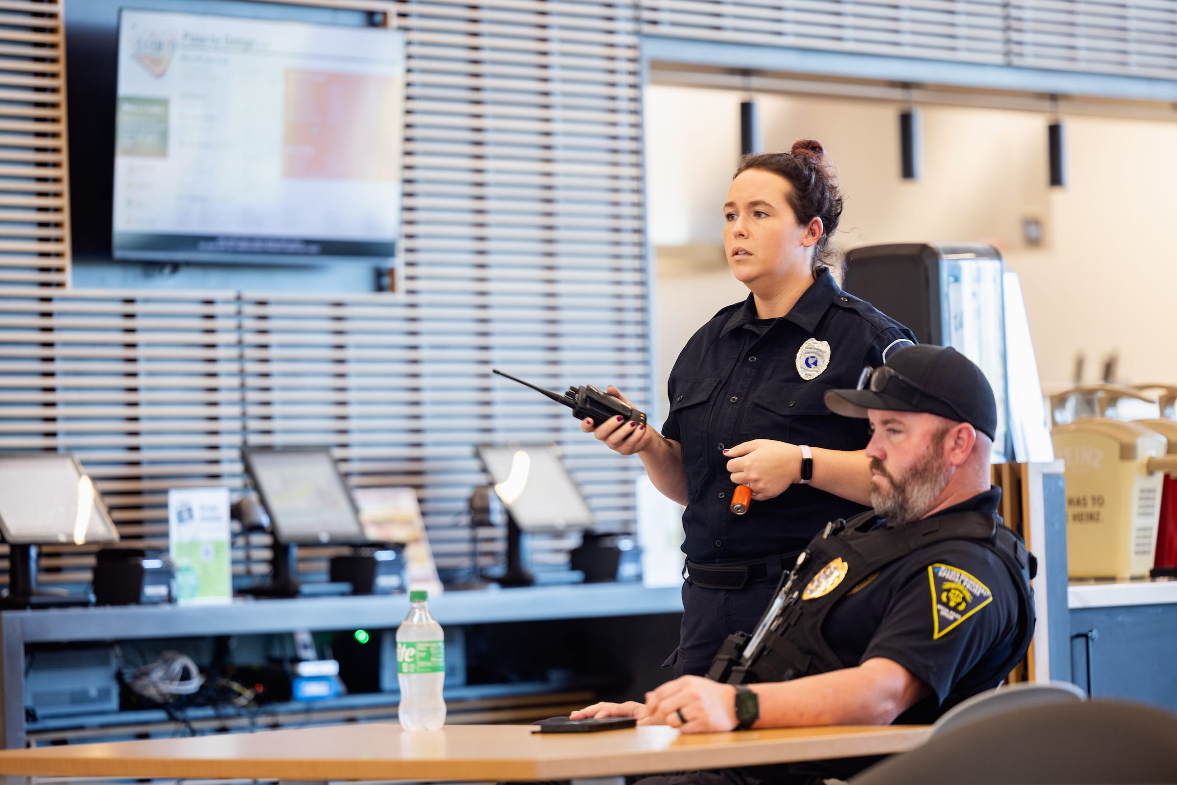 Criminal justice students at a dispatch console with radios and monitors