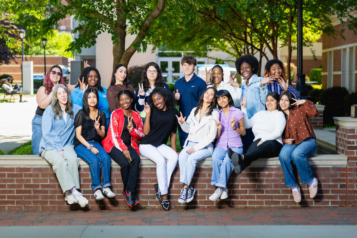 Members of the Campus Activities Board sitting outside on campus.