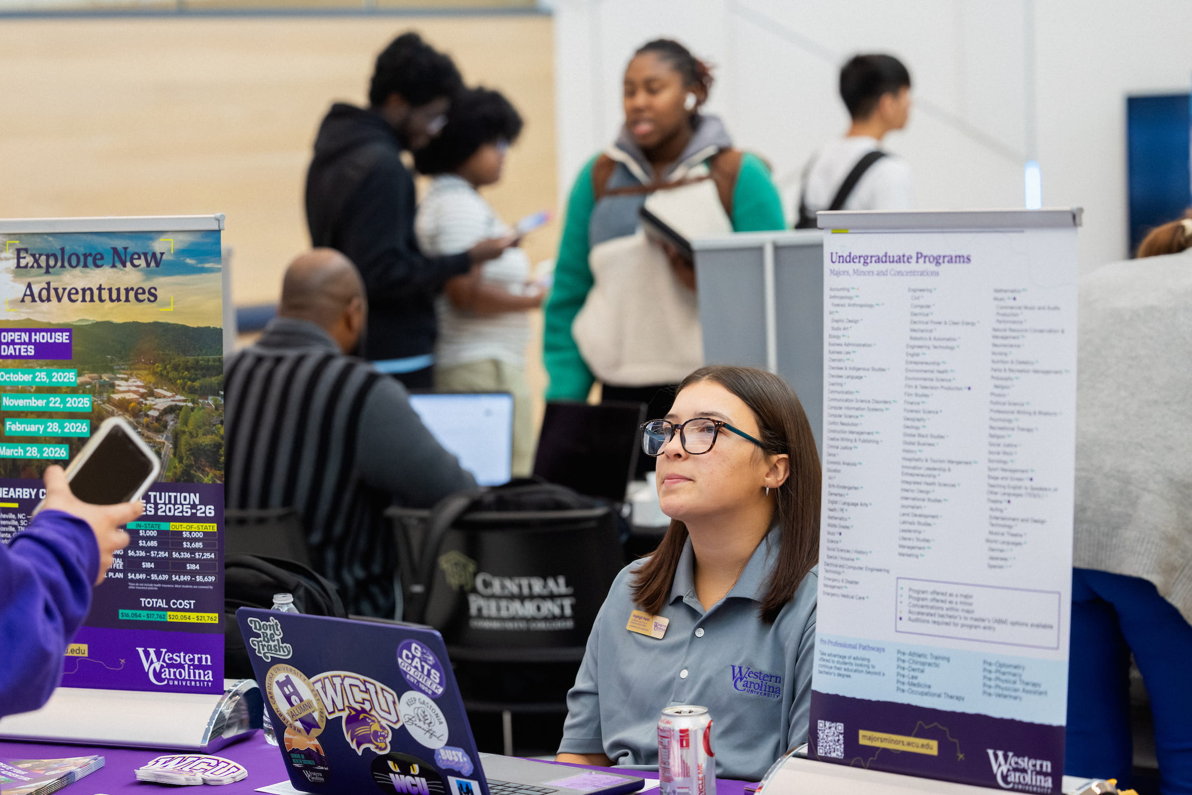 Student staffing a college information table with brochures and banners