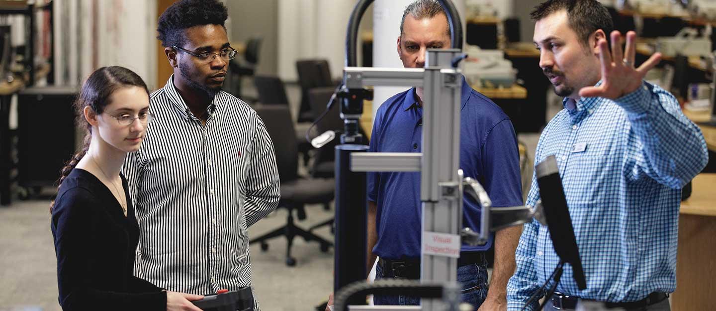 Instructor demonstrating test equipment to mechanical engineering students