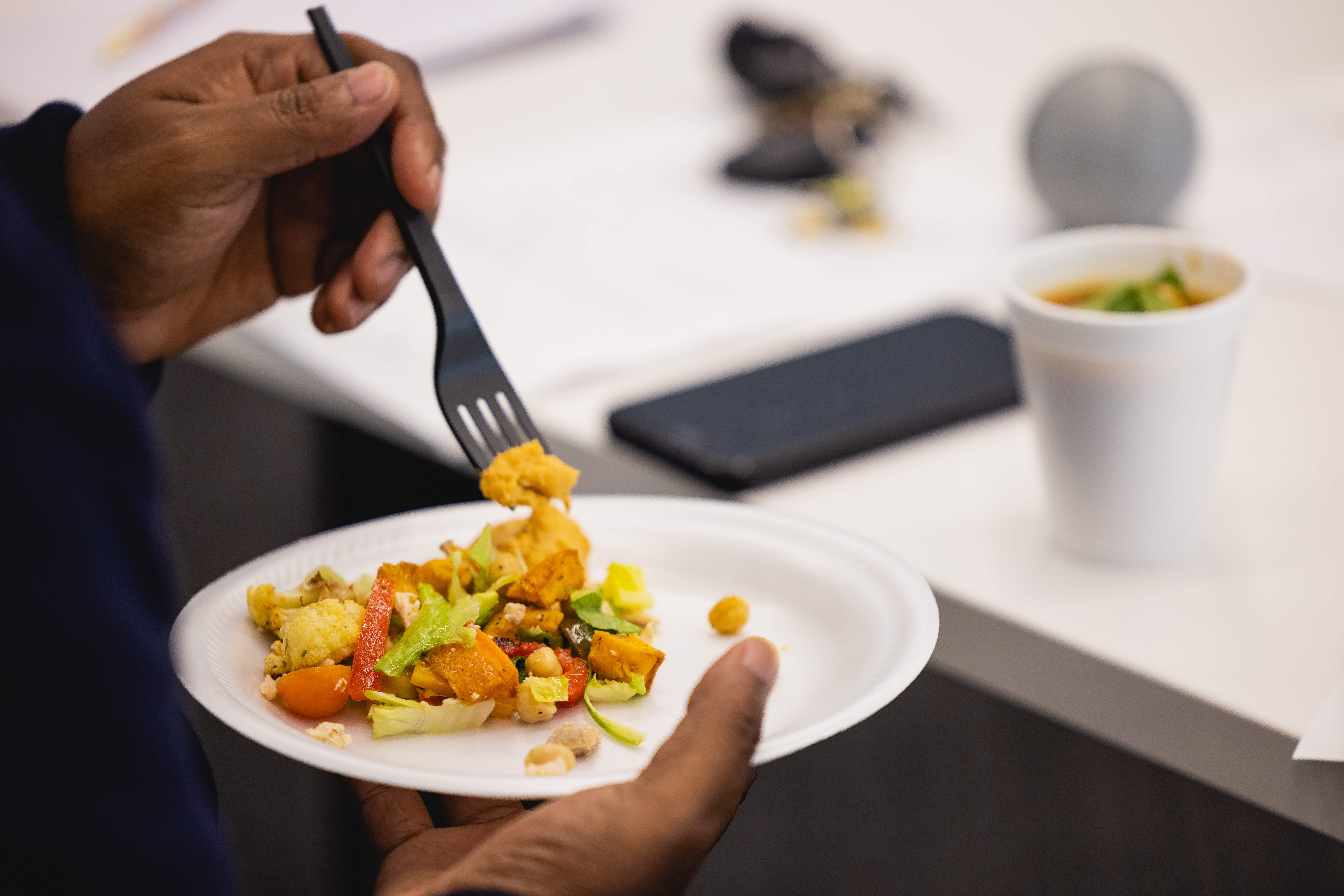 Hand holding a plate of food