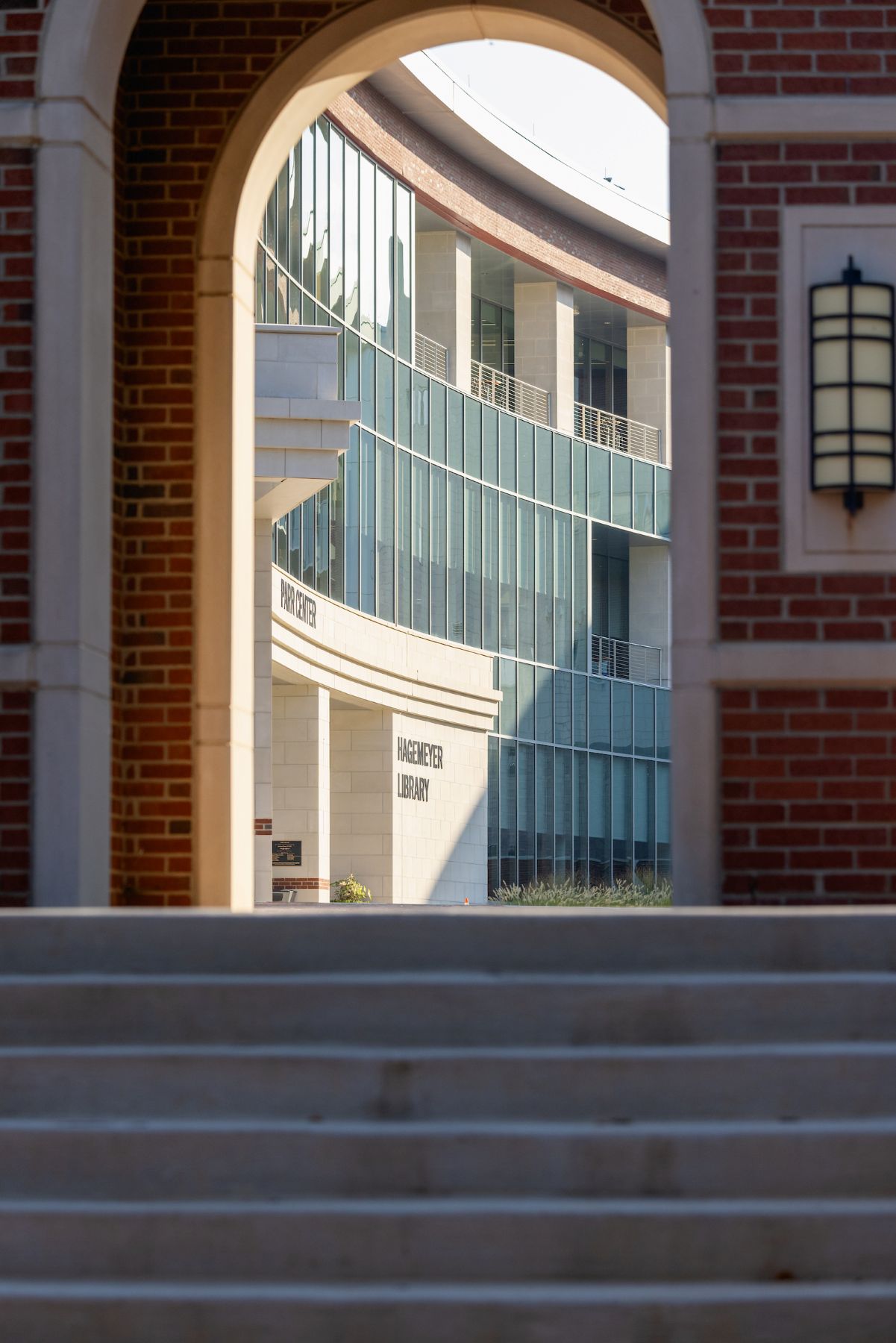 Concrete steps leading to a beautiful brick archway that looks through to Central Campus buildings.