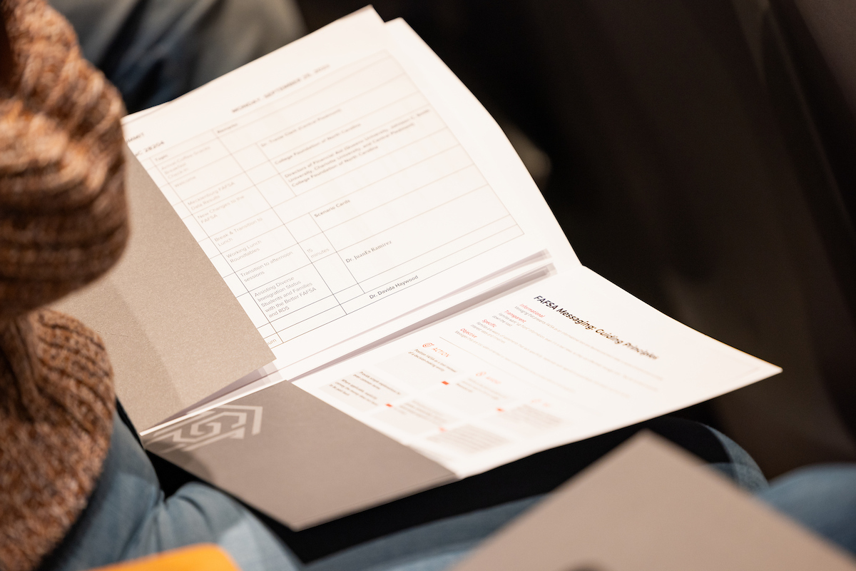 Open folder with pieces of paper within, resting on someone's lap