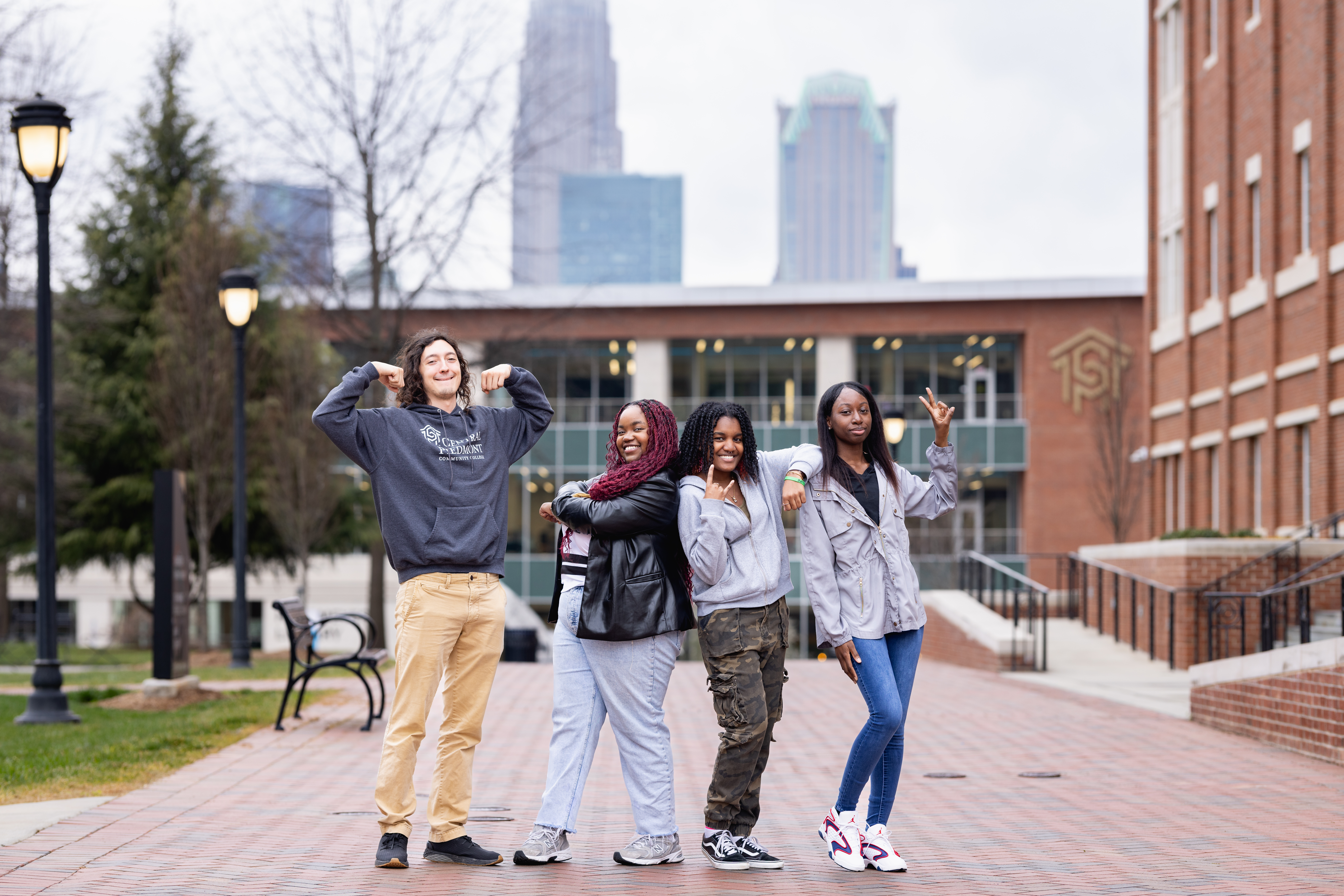 Four students in silly poses on the quad