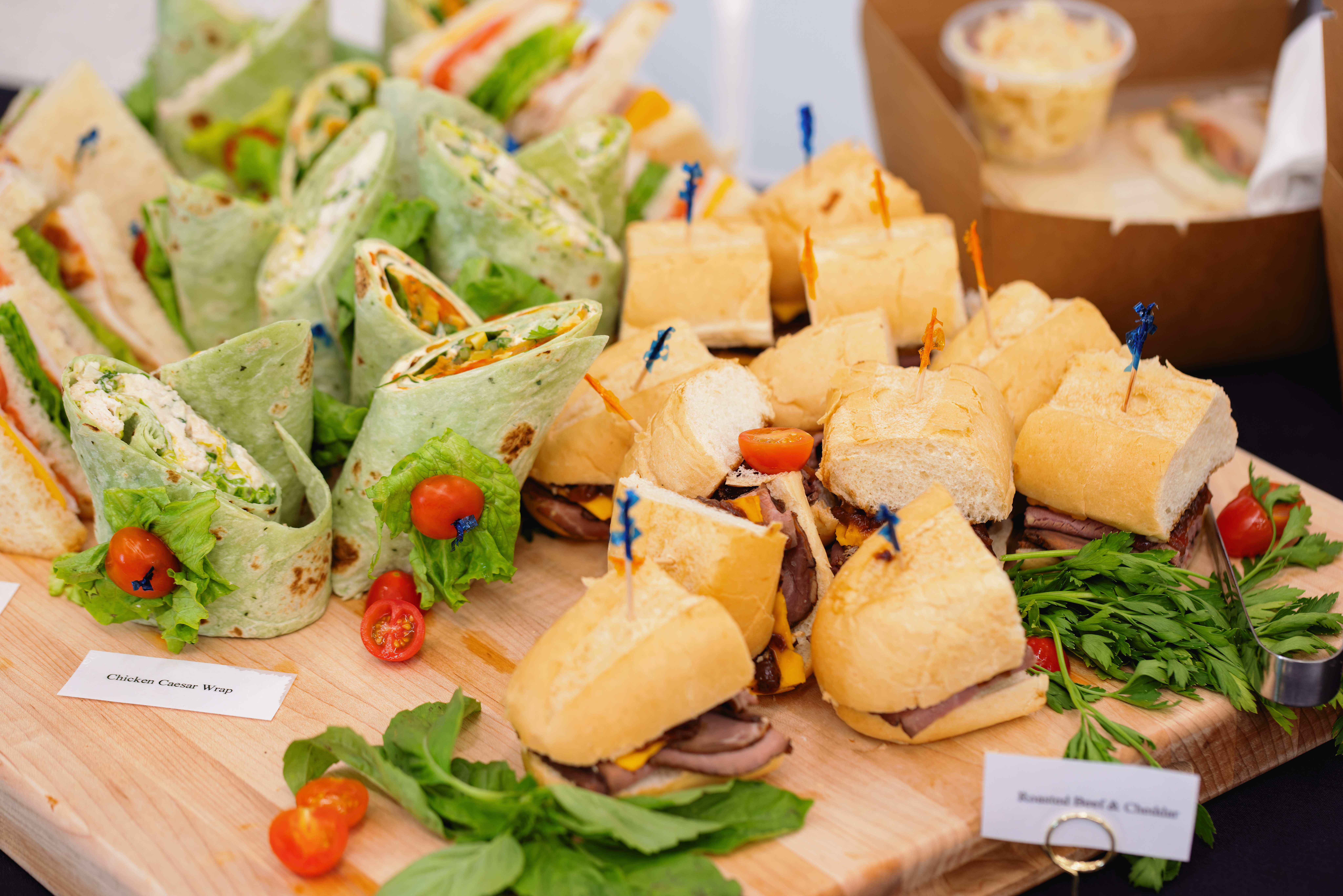 Wooden tray with selection of sandwiches and wraps