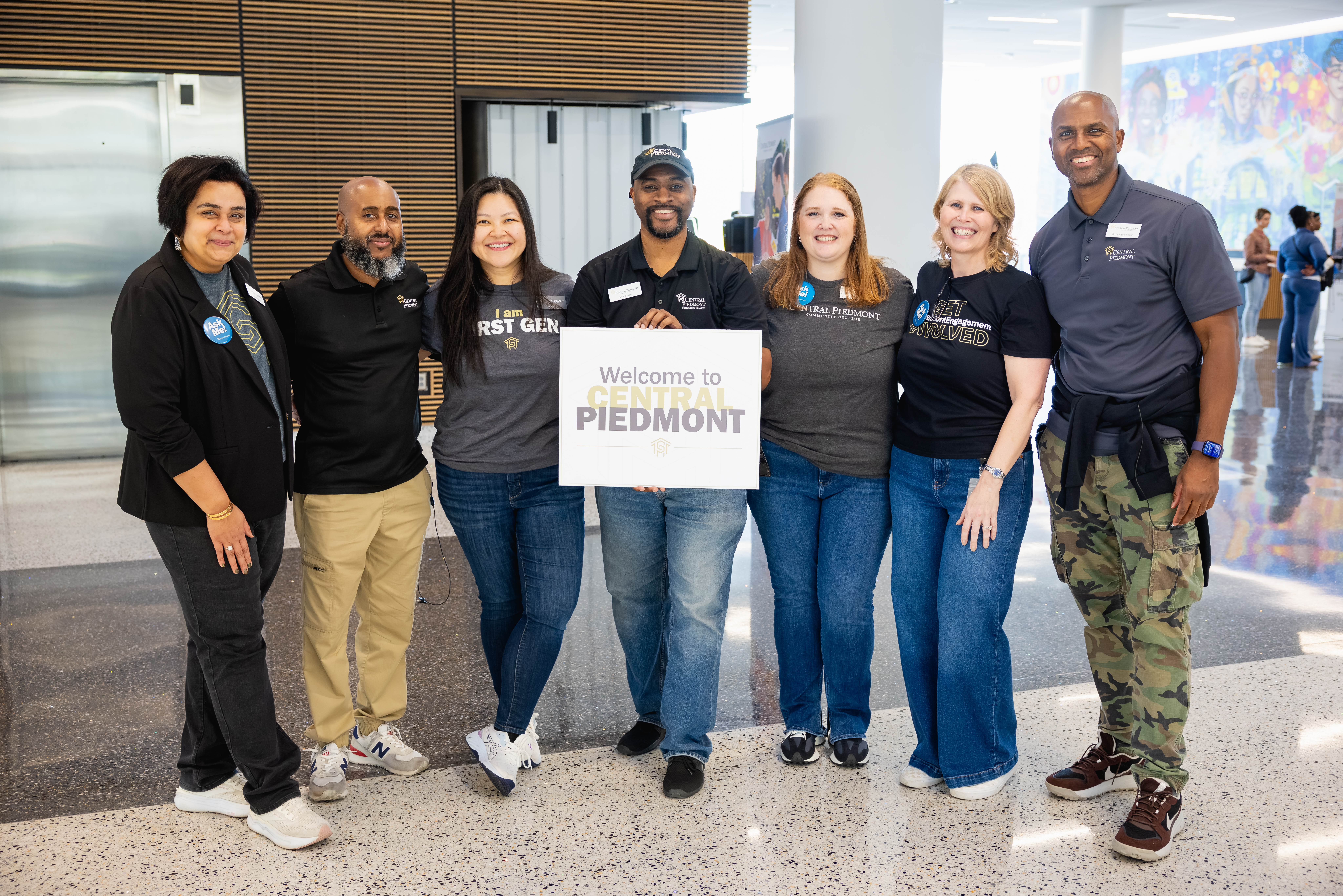 Staff posing with a welcome sign