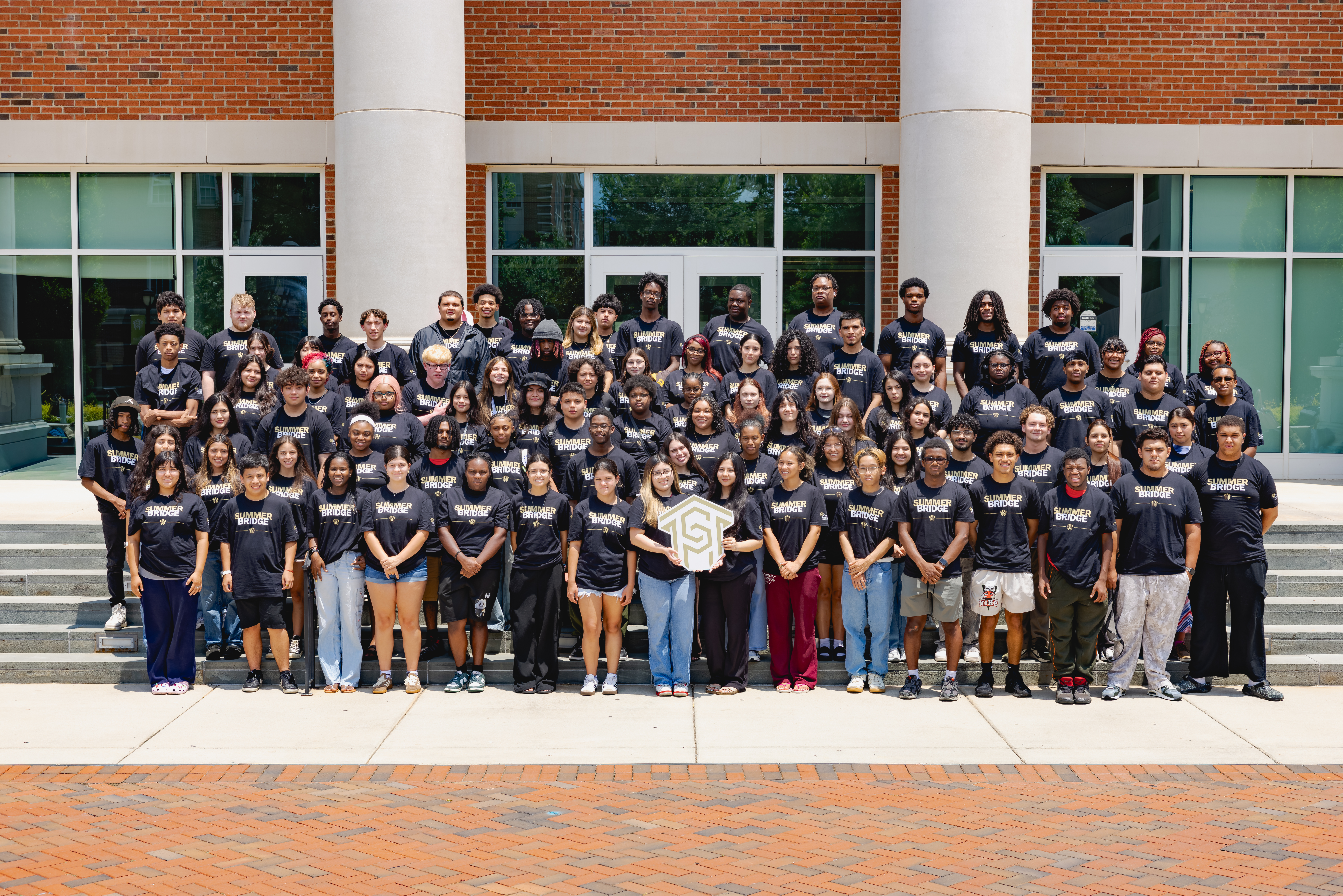 Nearly 100 Summer Bridge students in matching shirts on the steps