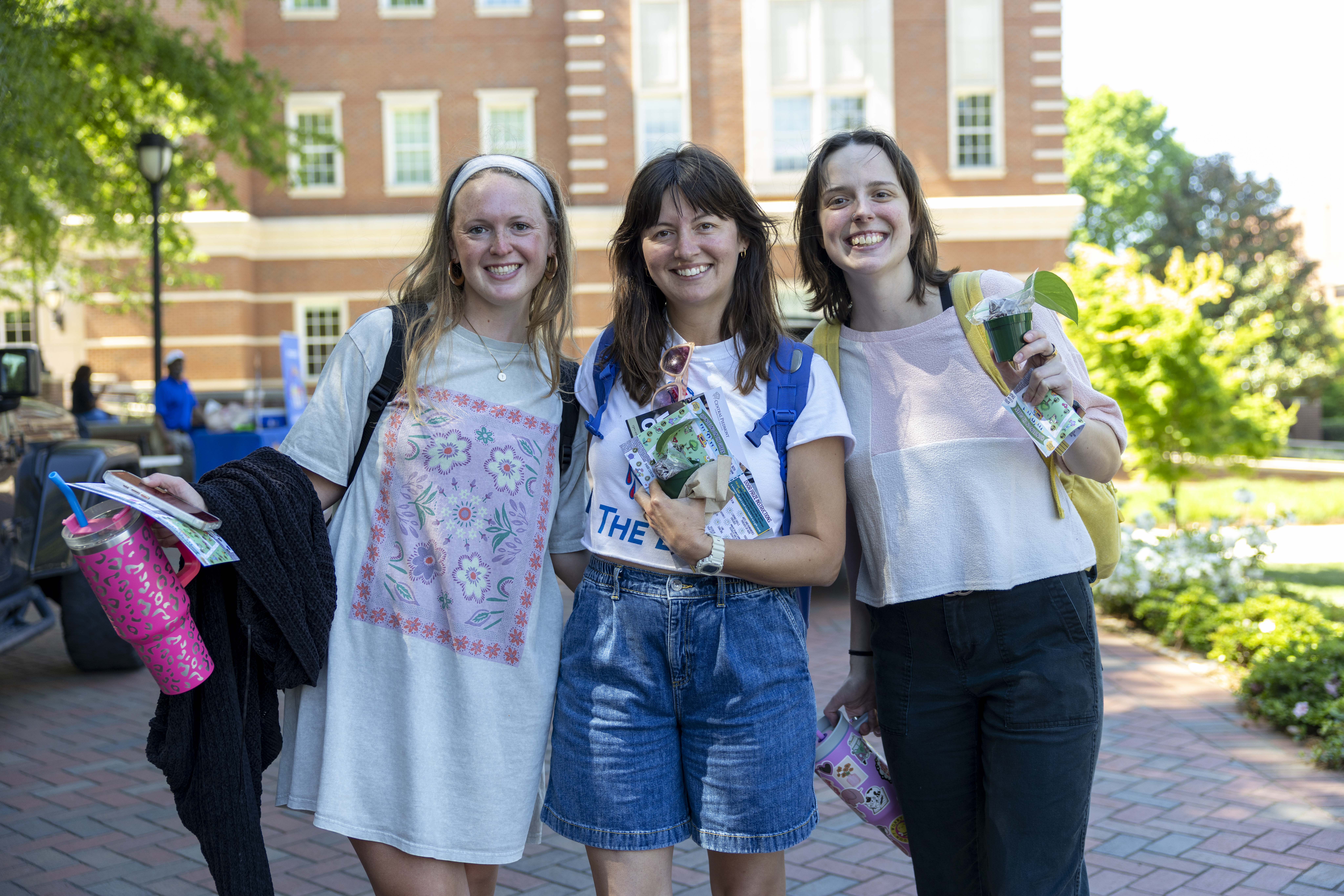 three central piedmont students smiling on campus