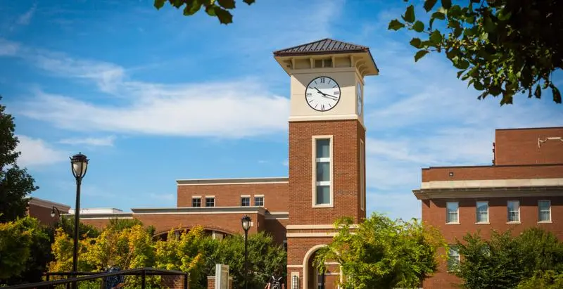 Central Campus clock tower building framed by trees