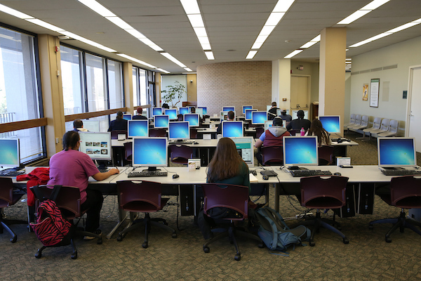 Students seated at digital workstations in the library