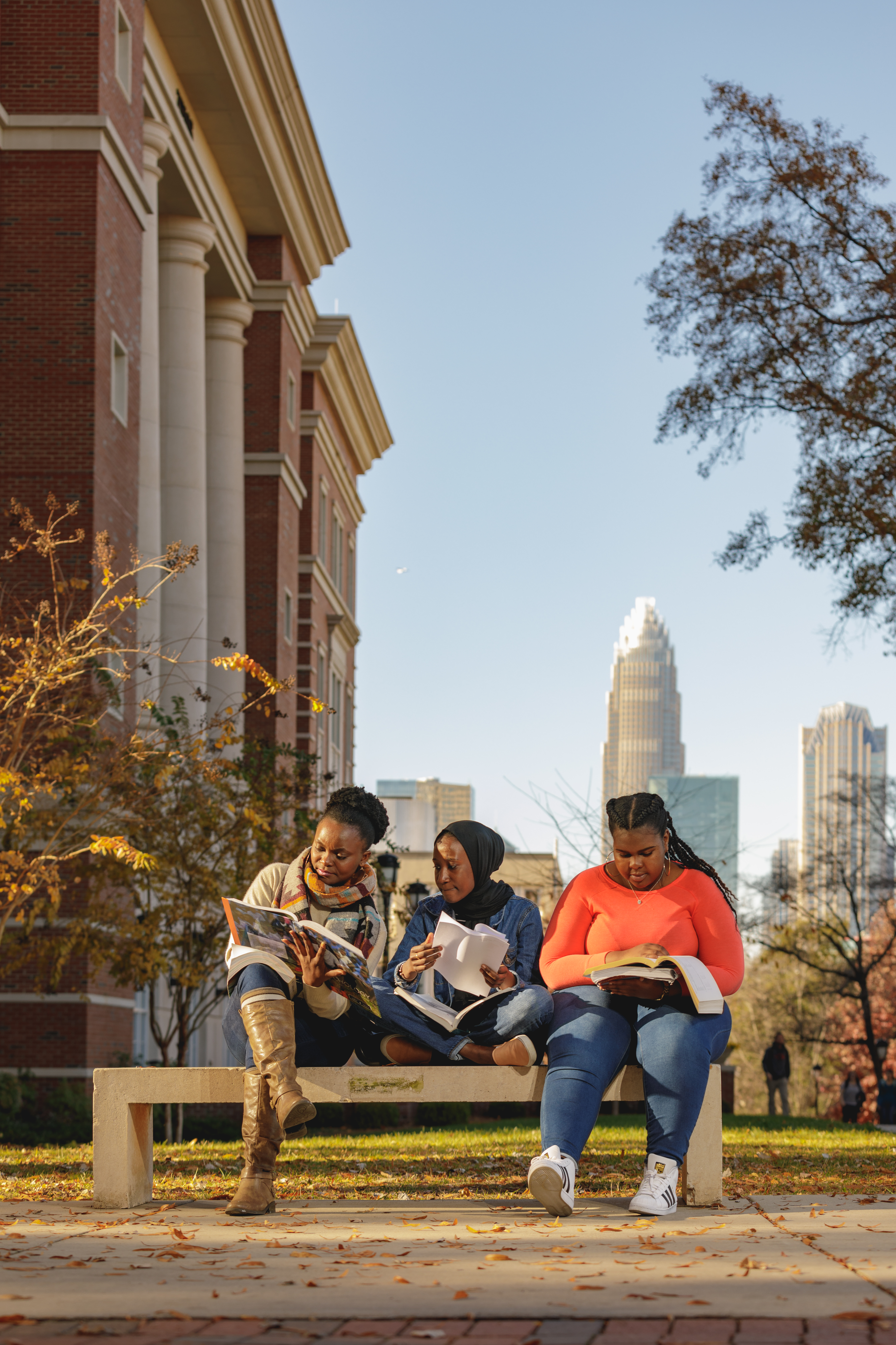 3 central piedmont students reading on campus