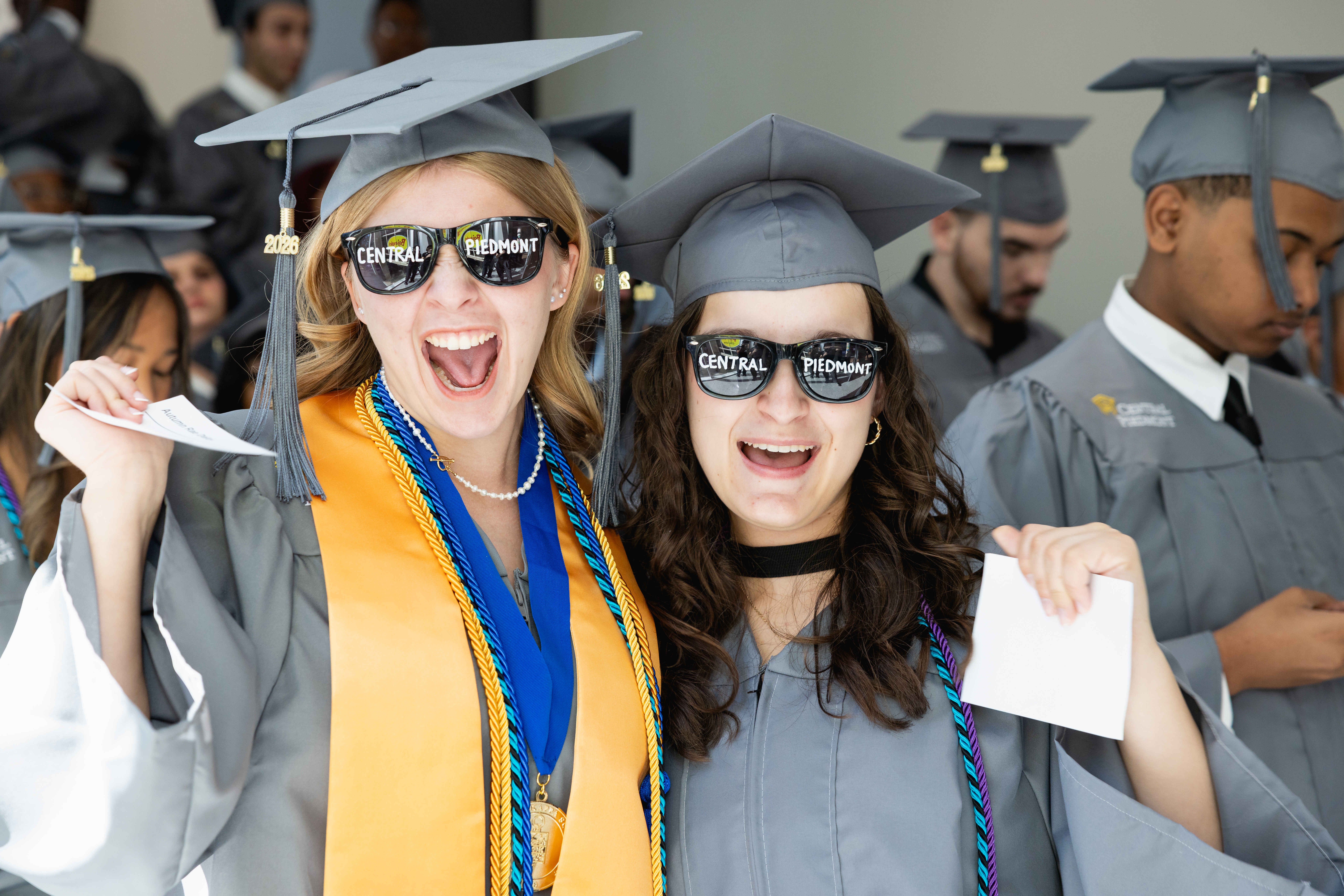 Two students wearing sunglasses with Central Piedmont written across the lenses