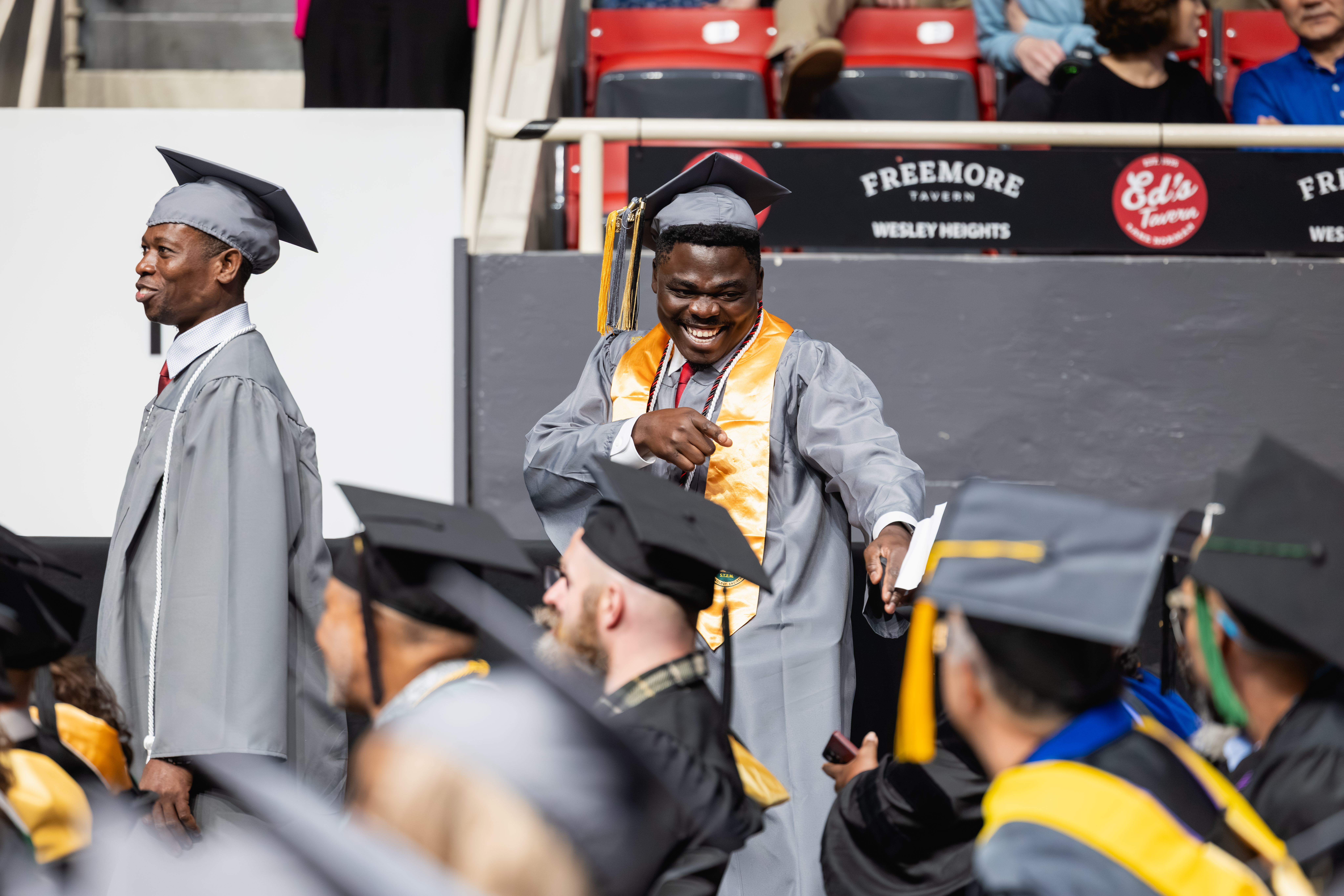 Central piedmont graduate in cap and gown posing for photo