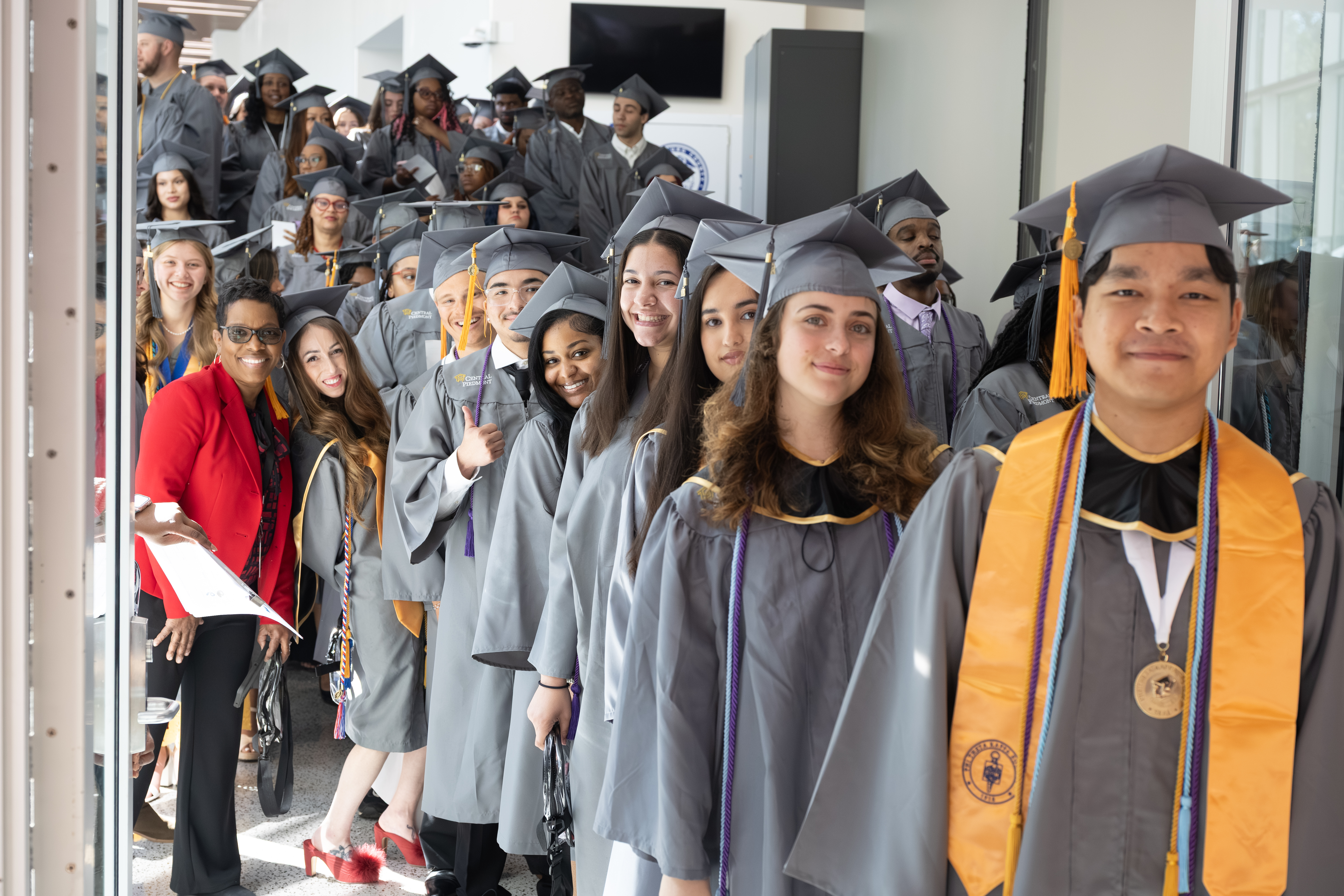 Hallway full of students wearing caps and gowns ready to enter the commencement ceremony