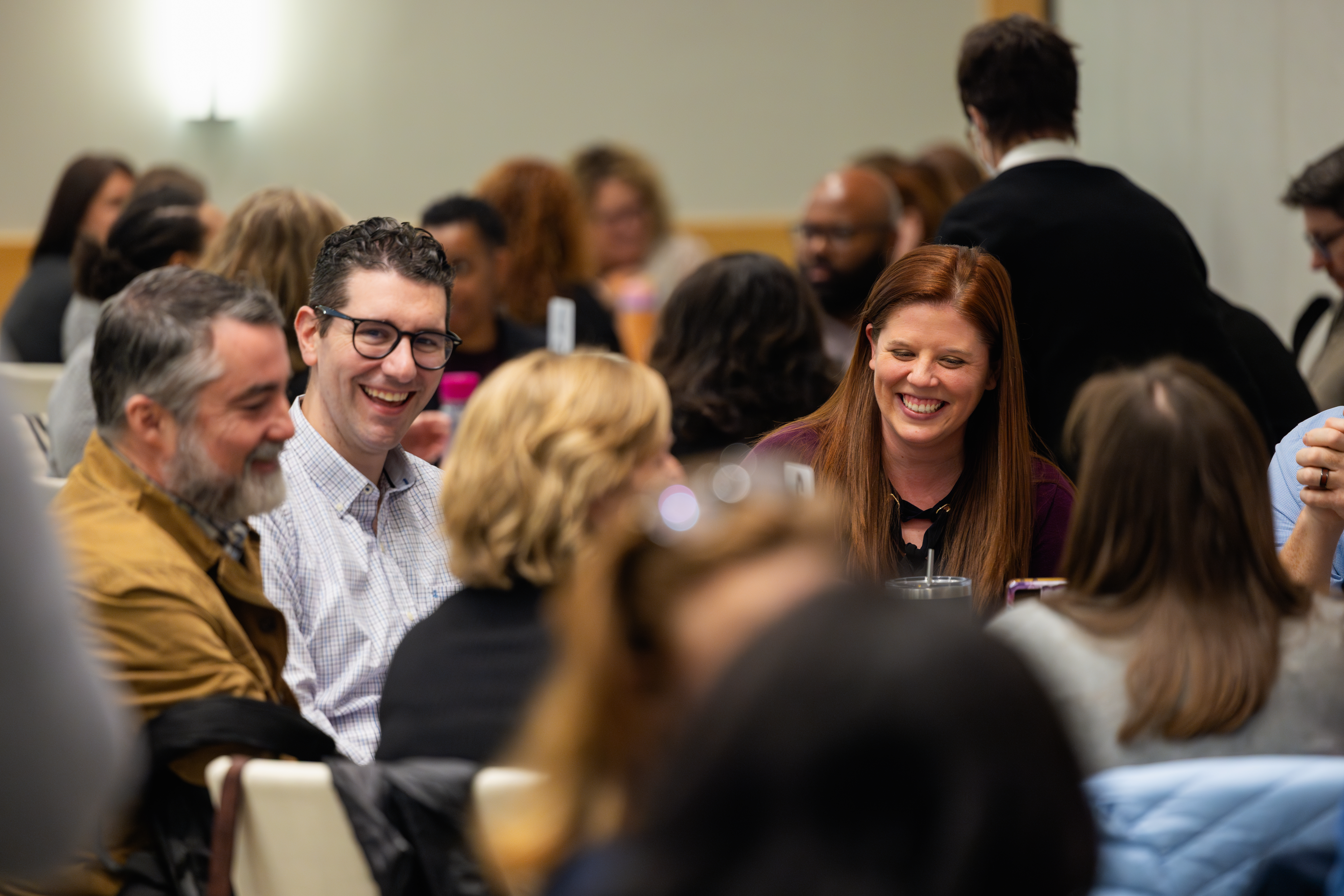 Smiling staff sitting at a table in a crowded room
