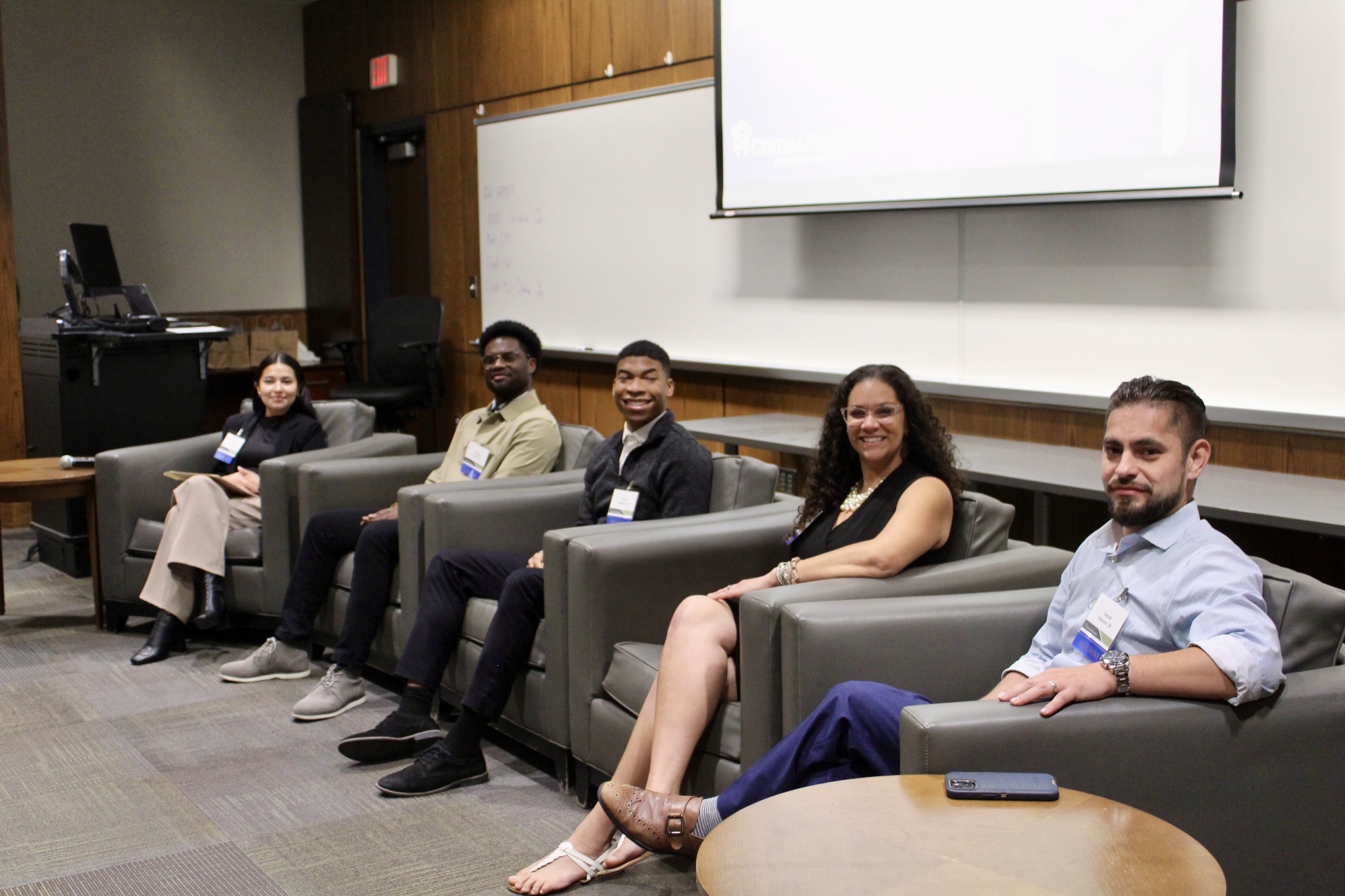 Five alumni sitting in front of a room as part of an alumni panel discussion