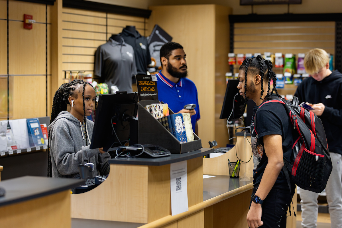 Student checking out at the Campus Store cash register