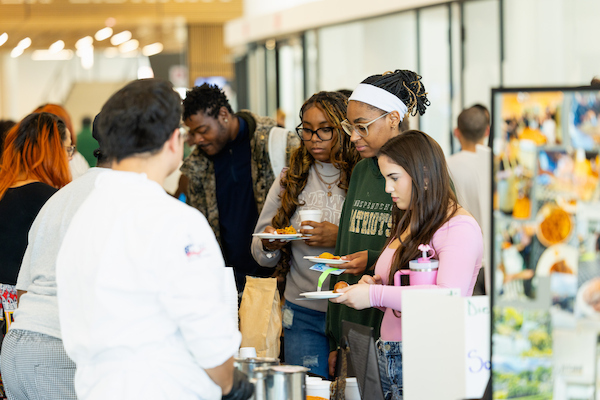 Students gathering around a food table at a Center for Global Engagement study abroad fair.