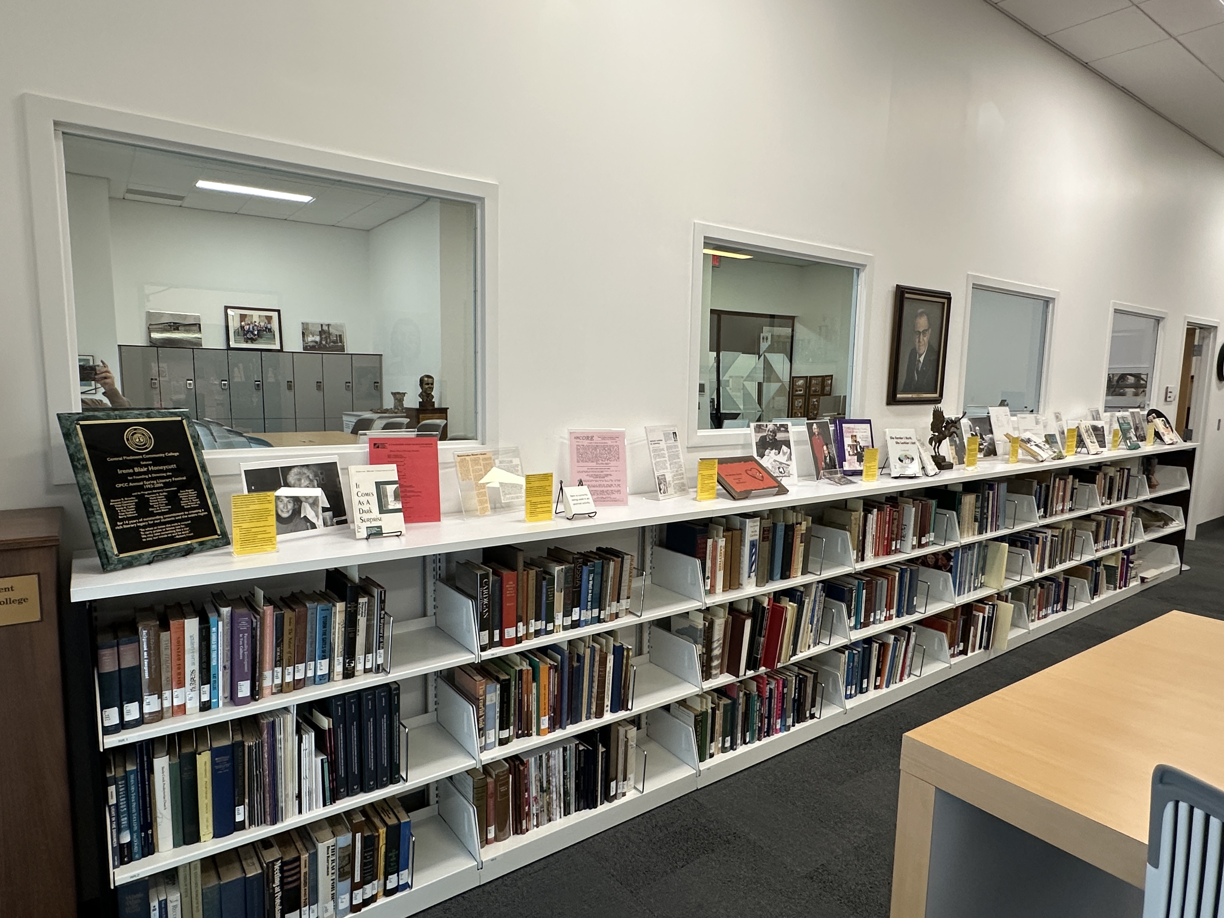 Archives reading room with a long wall of bookshelves and glass-walled study rooms