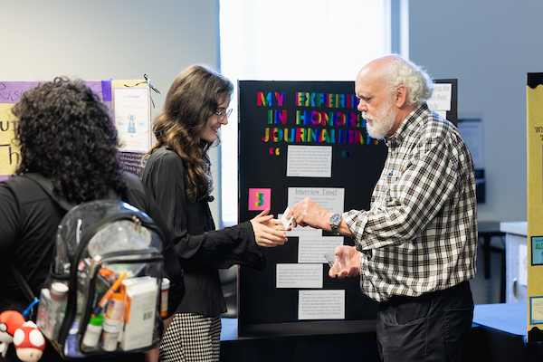 Honors students presenting at an expo at Central Piedmont and capitalizing on networking opportunities.