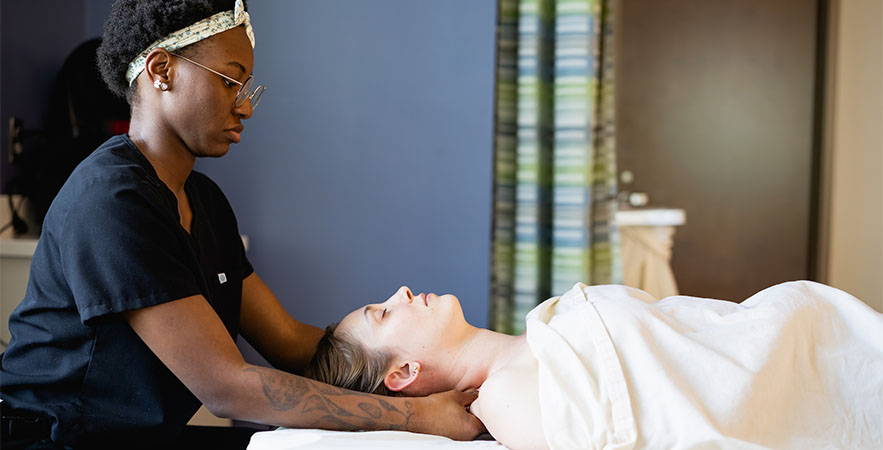 A Central Piedmont massage therapy student performing a massage