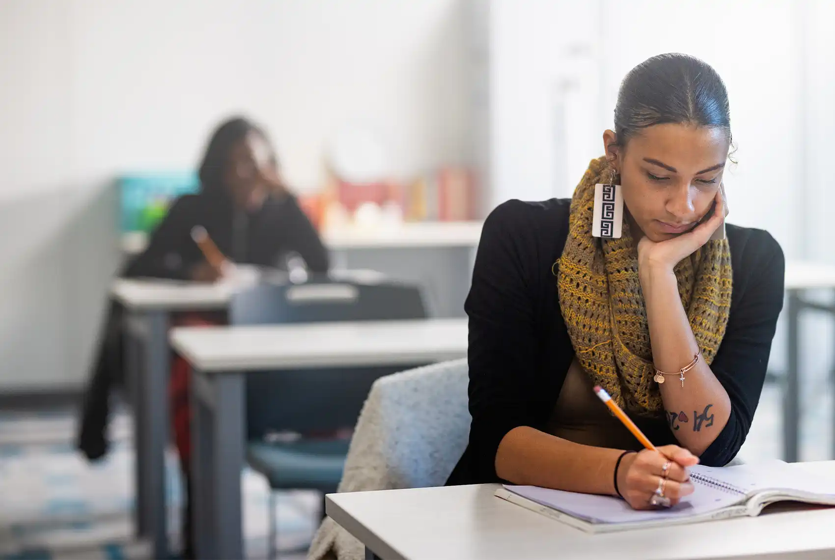 A Central Piedmont student in a classroom taking a test using a pencil and paper