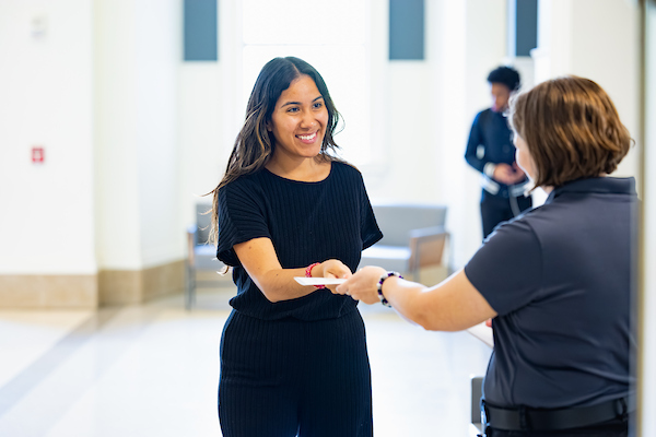 Faculty or staff member handing a nursing student a piece of paper