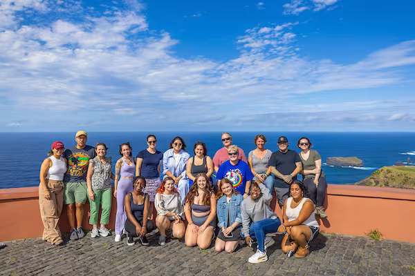 A study abroad cohort posing for a photo in front of the Atlantic Ocean