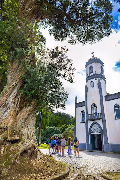 Central Piedmont Community College students standing outside a rural church during a study abroad trip to Portugal.
