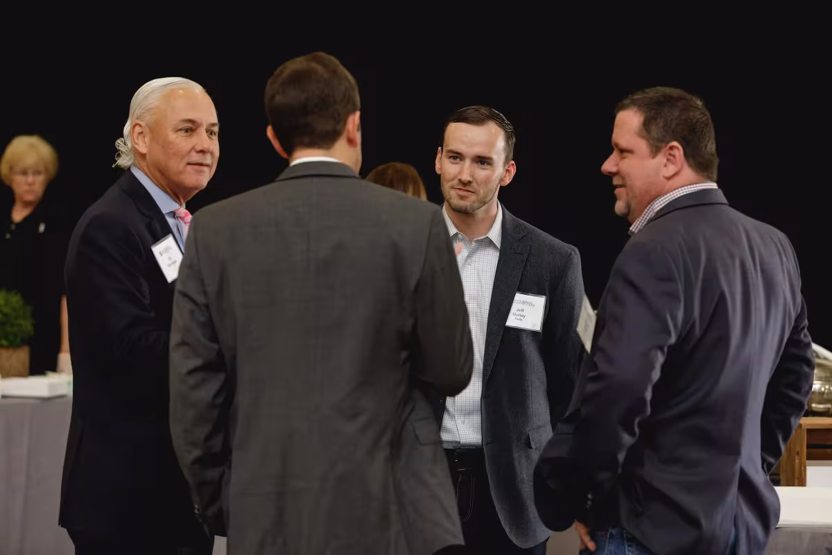 Alumni in business dress talking at a networking reception