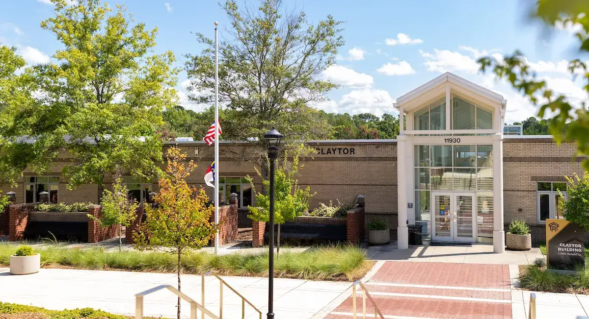 Exterior of brick building with glass entryway and walkways in front on Central Piedmont’s Merancas Campus.