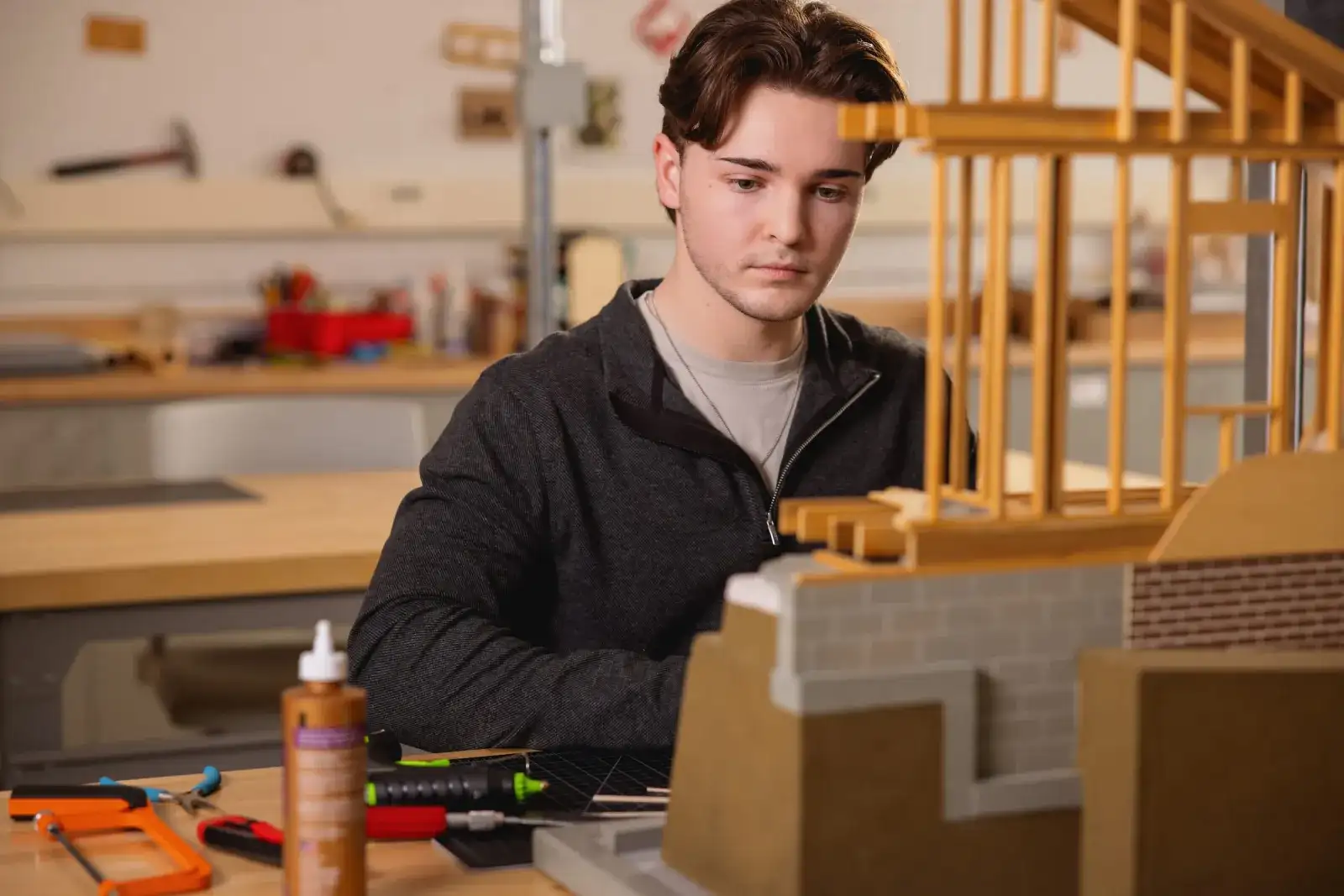 Architectural Technology student assembling a timber scale model of a building