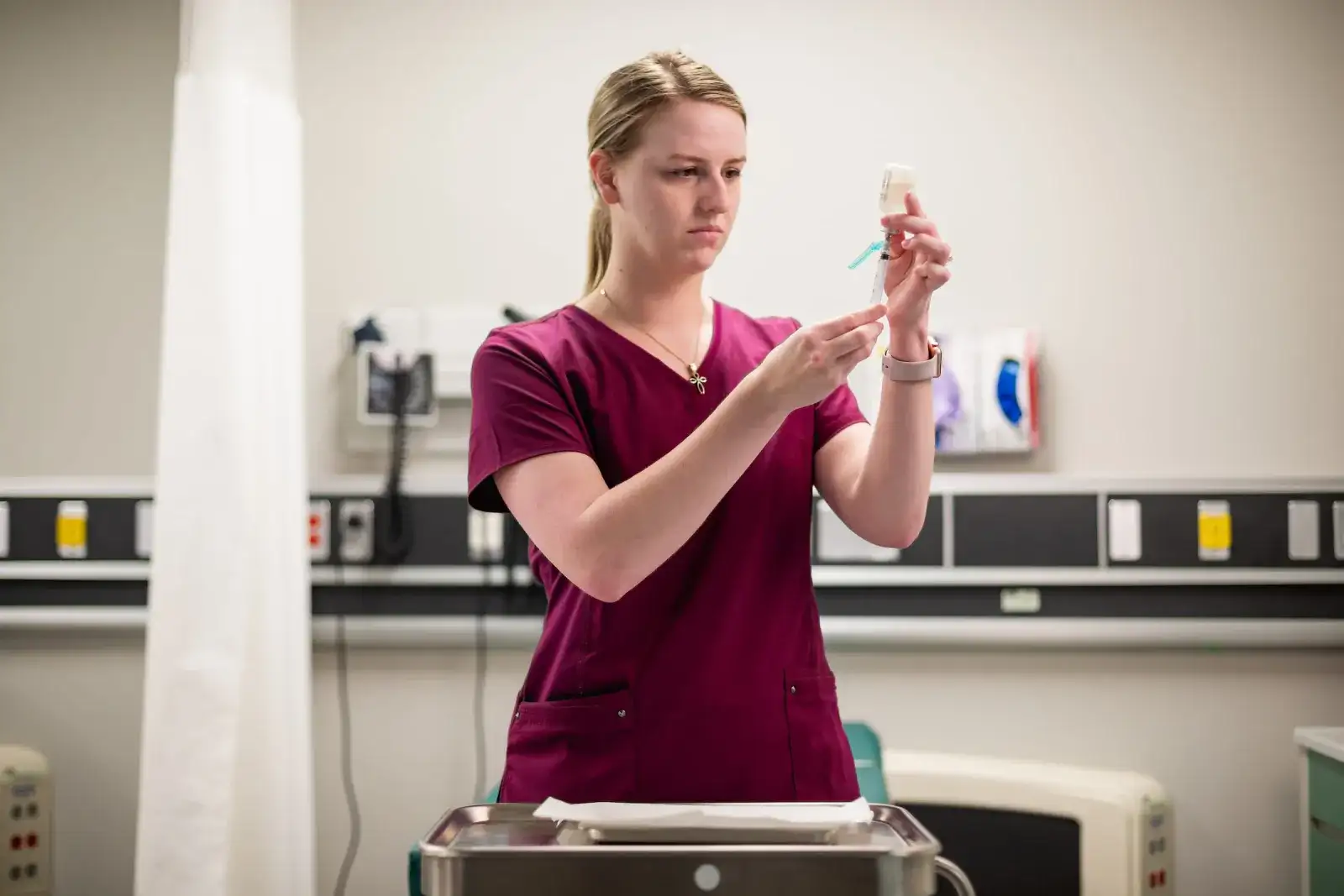 Nursing student preparing a syringe in a clinical skills lab