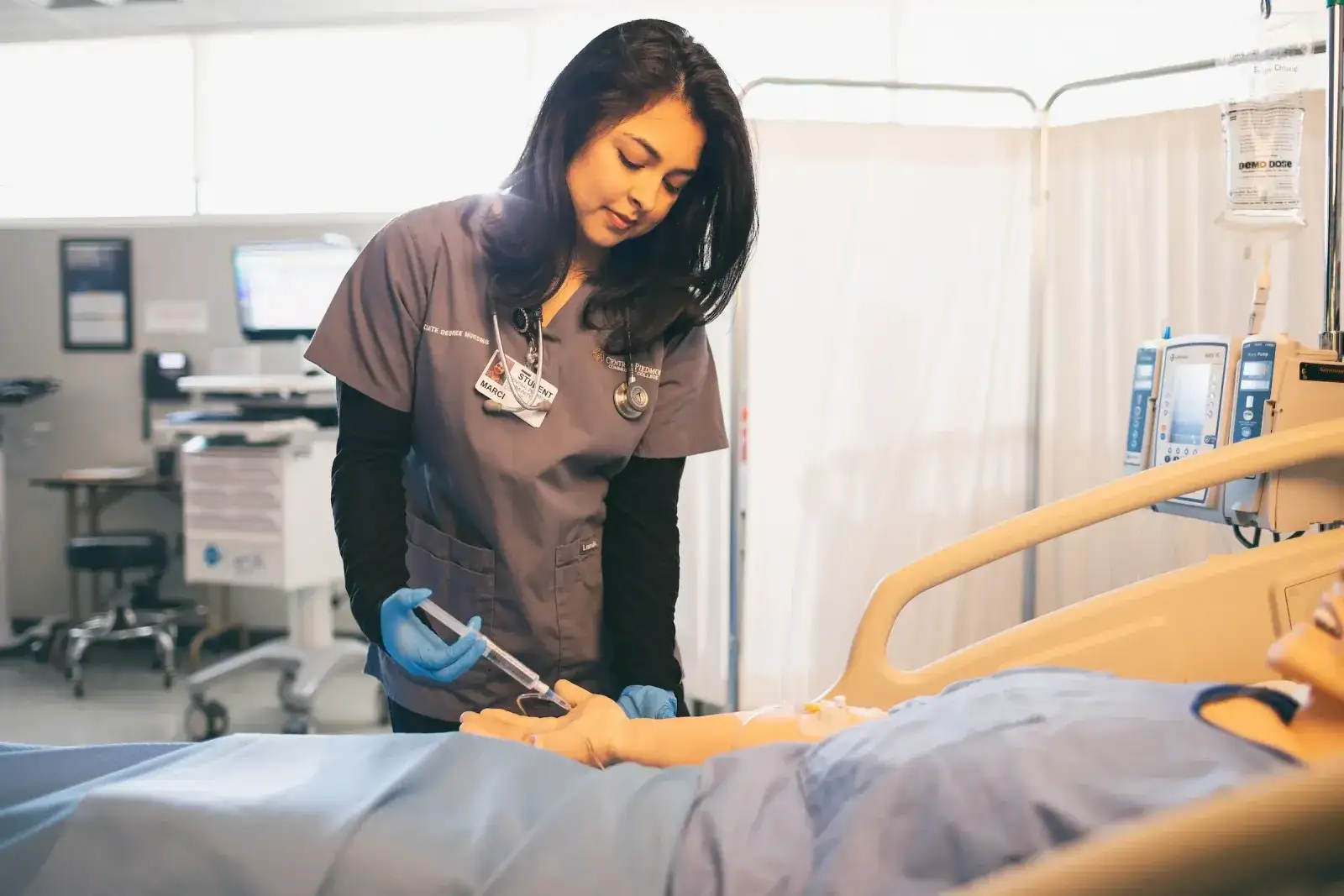 Nursing student checking a patient simulator in a clinical skills lab