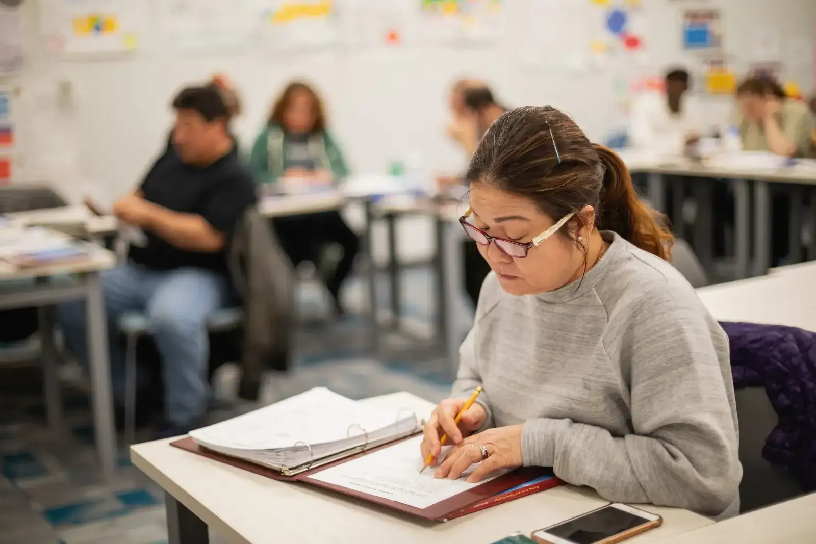 Student writing in a notebook during class