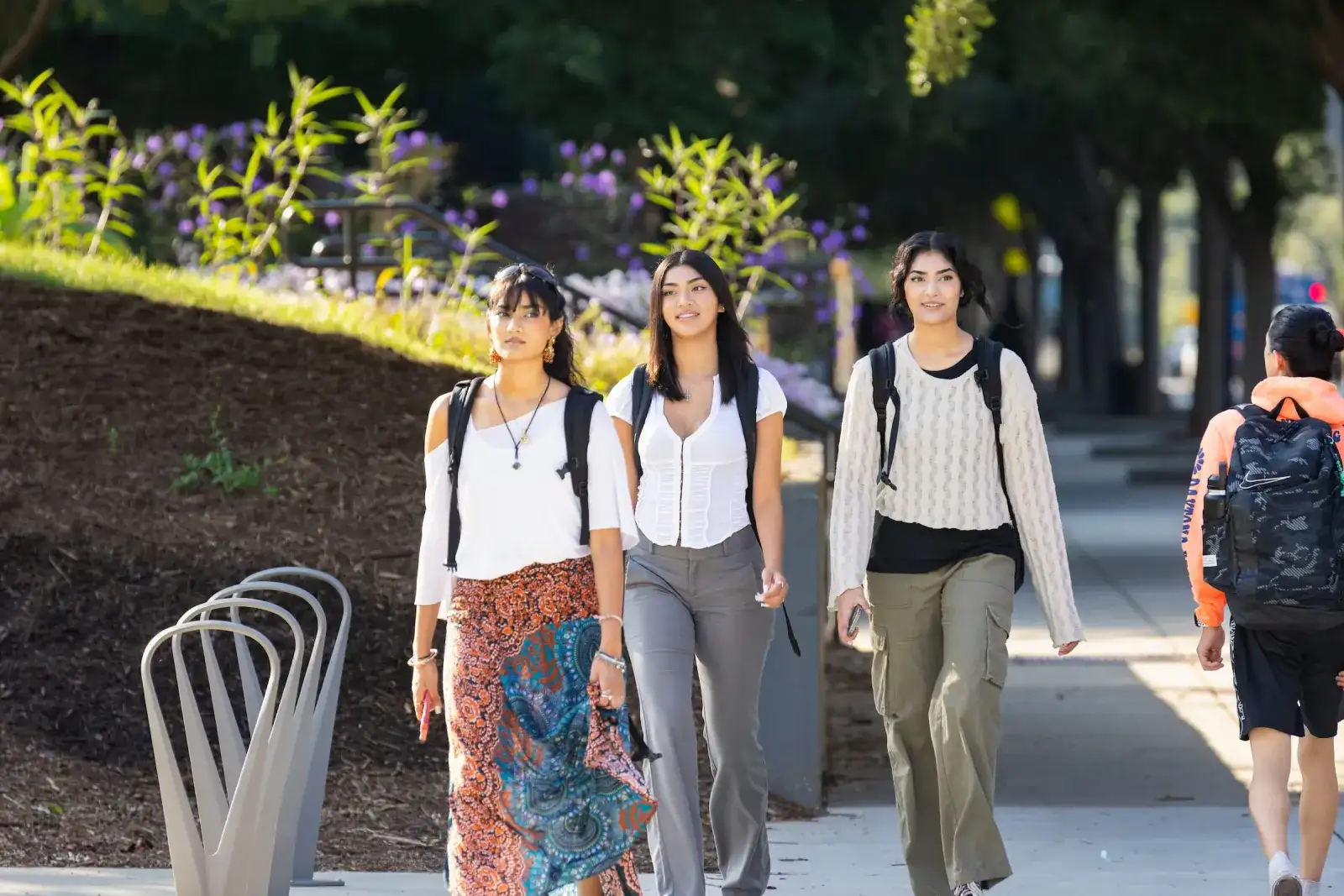 Three students walking together along a campus path