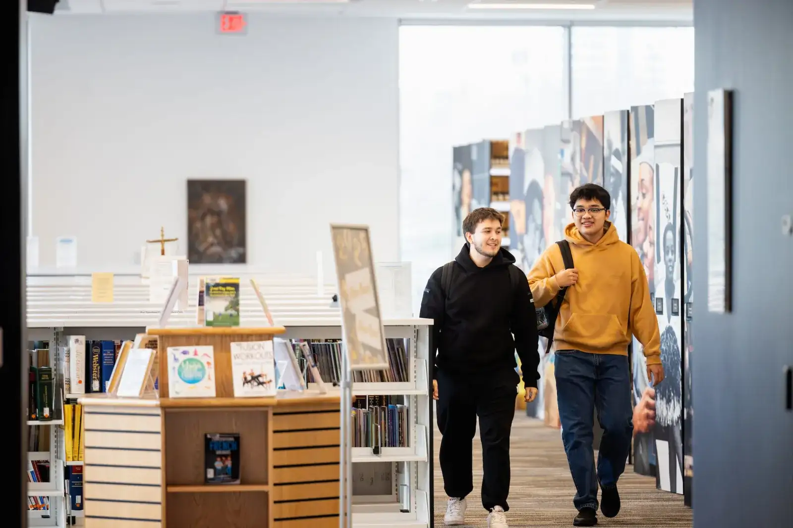 Students walking through an interior design studio lined with material samples