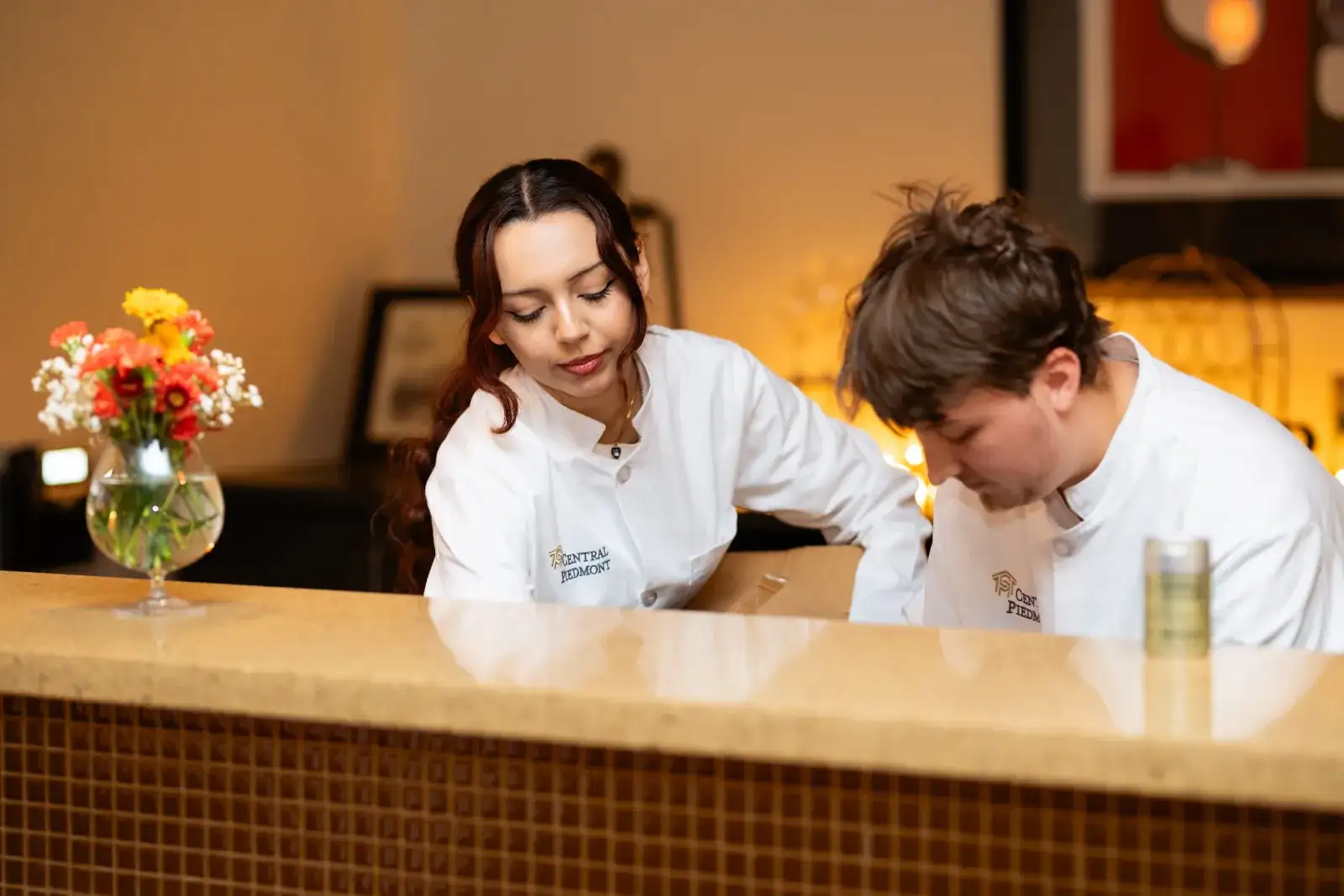 Hospitality students working behind a hotel reception desk