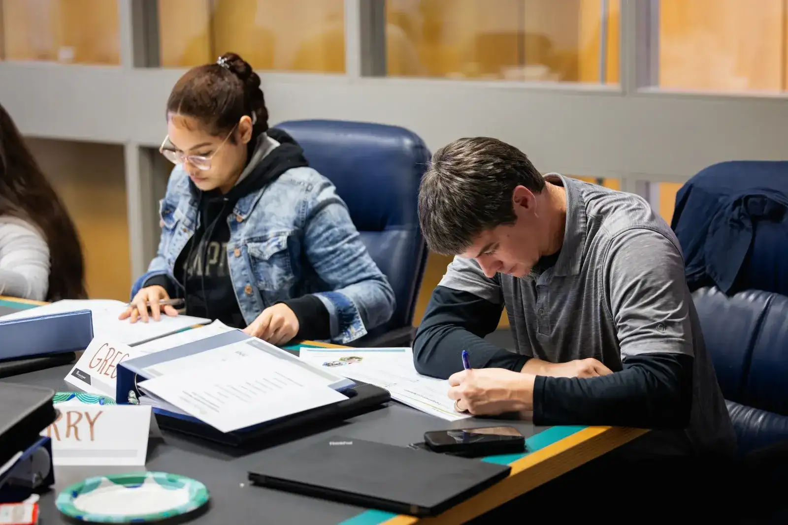 Students working through papers at a study table