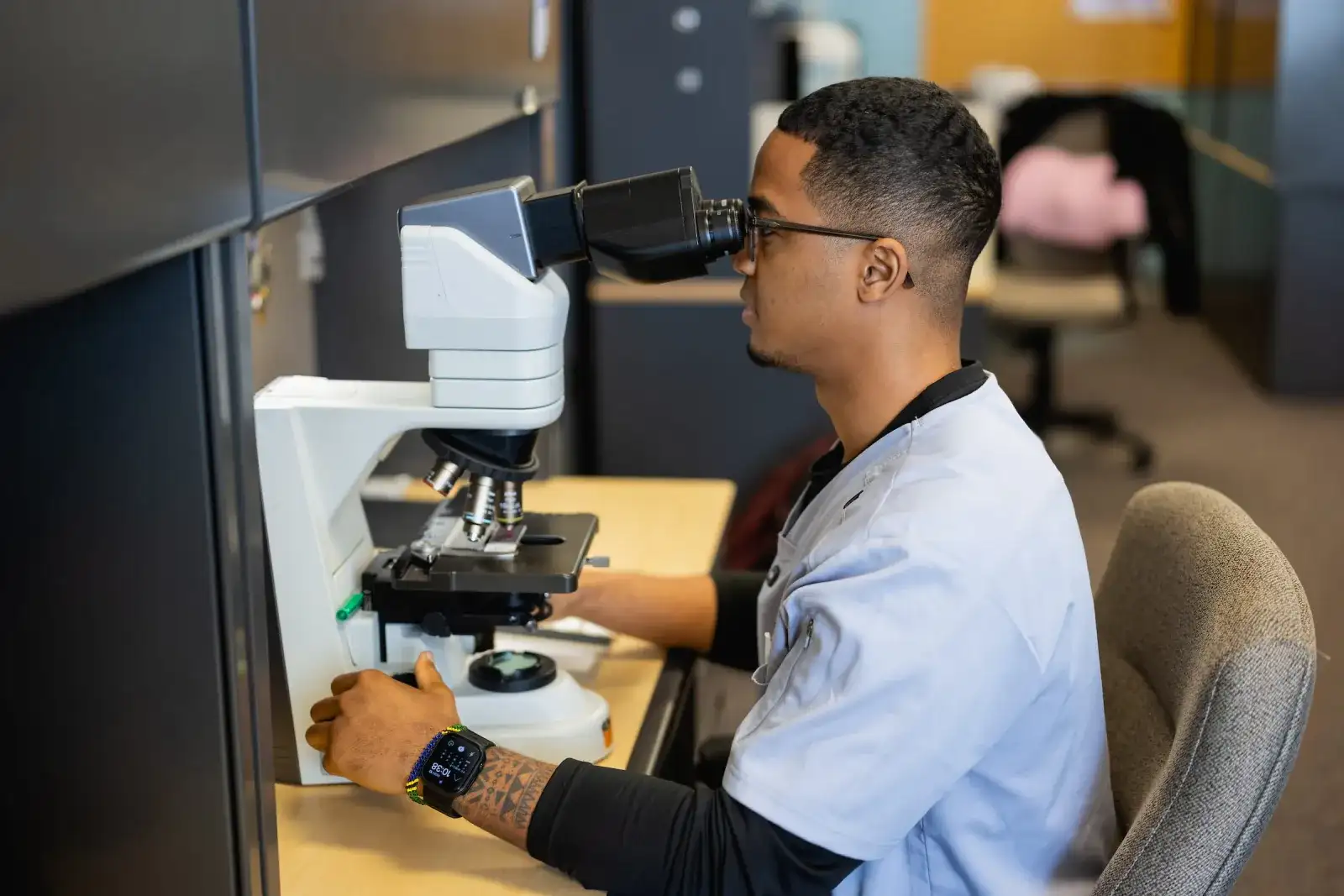Cytotechnology student examining a specimen through a microscope