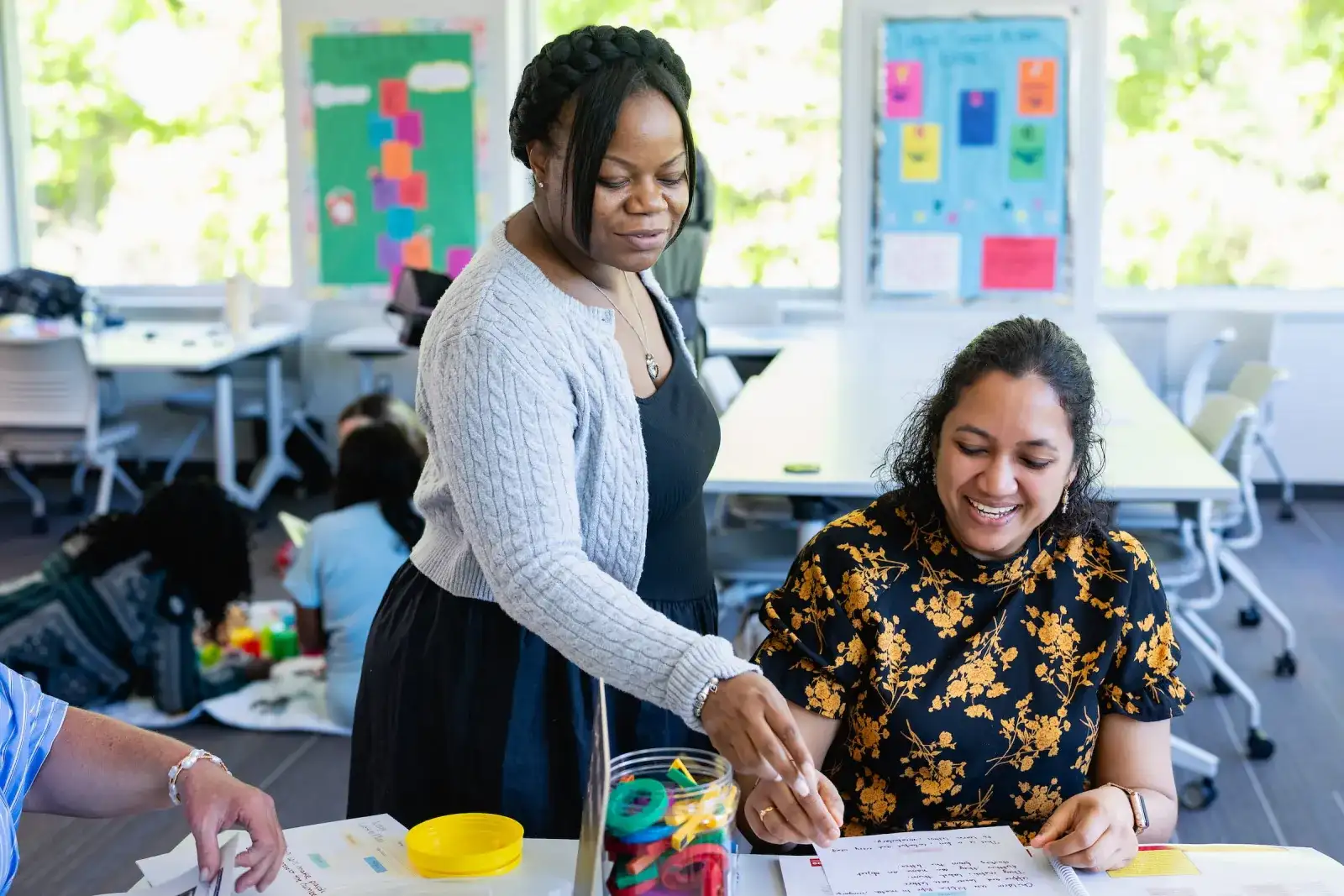 Early childhood education students planning activities in a colourful classroom