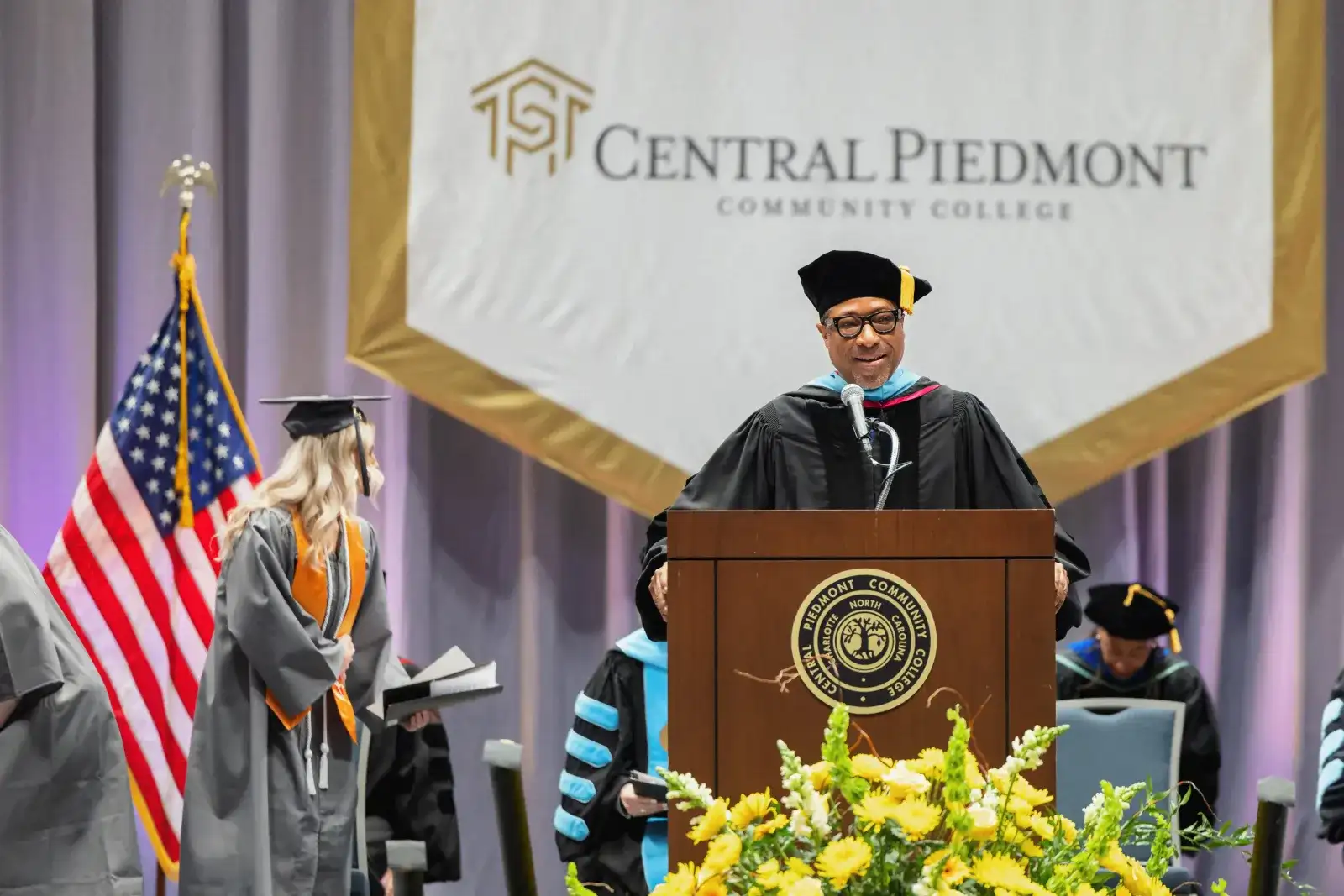 Commencement speaker in academic regalia at the lectern