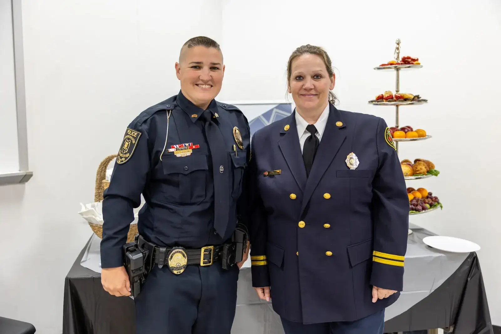 A police officer and a fire officer in dress uniform at a public safety reception
