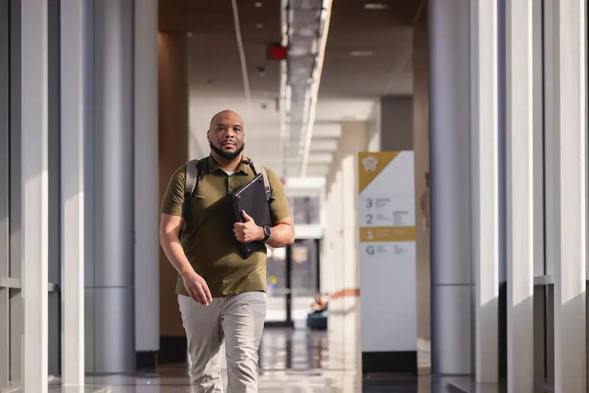 Student walking down the hallway of an academic building