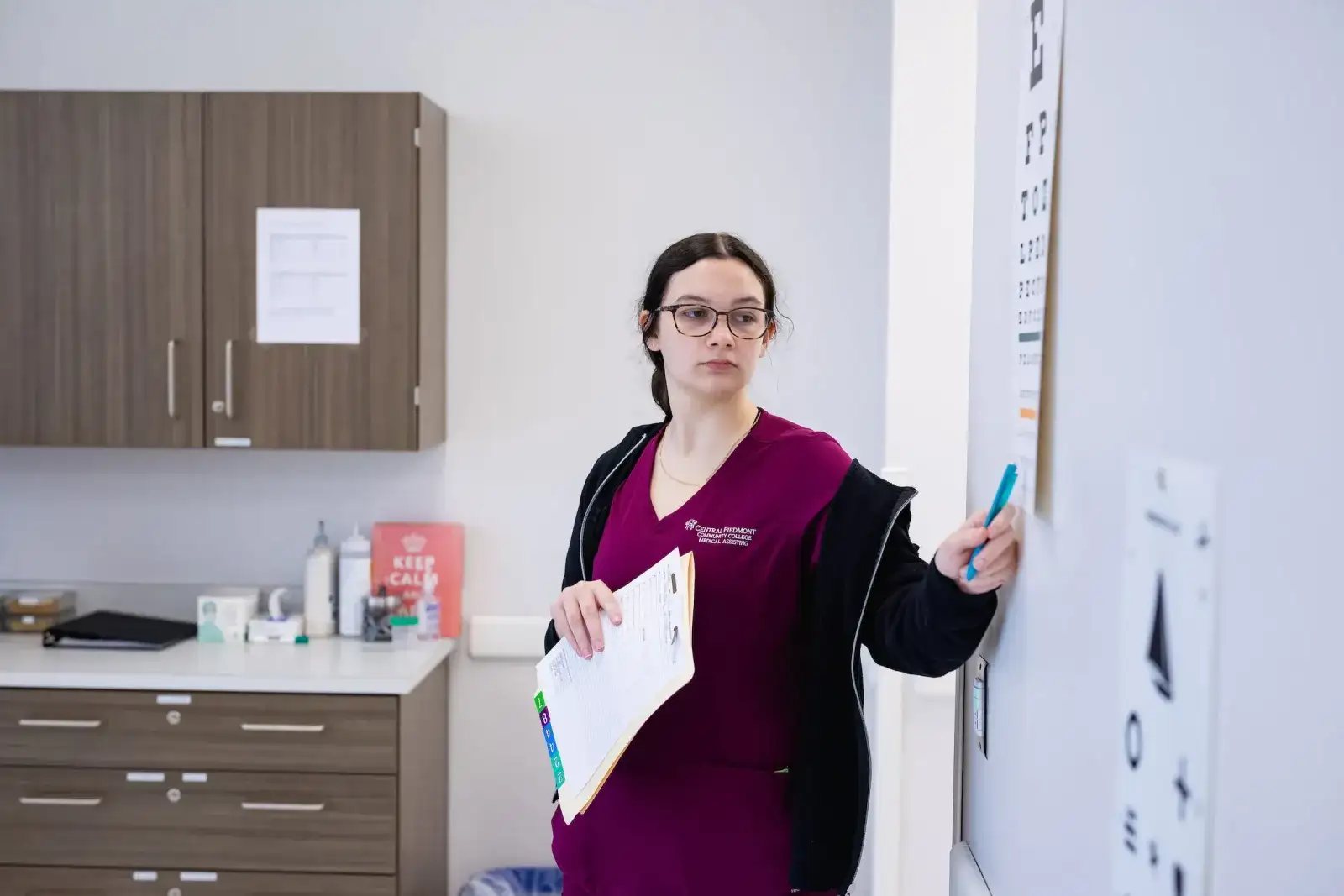 Healthcare student writing on a whiteboard in a clinical classroom