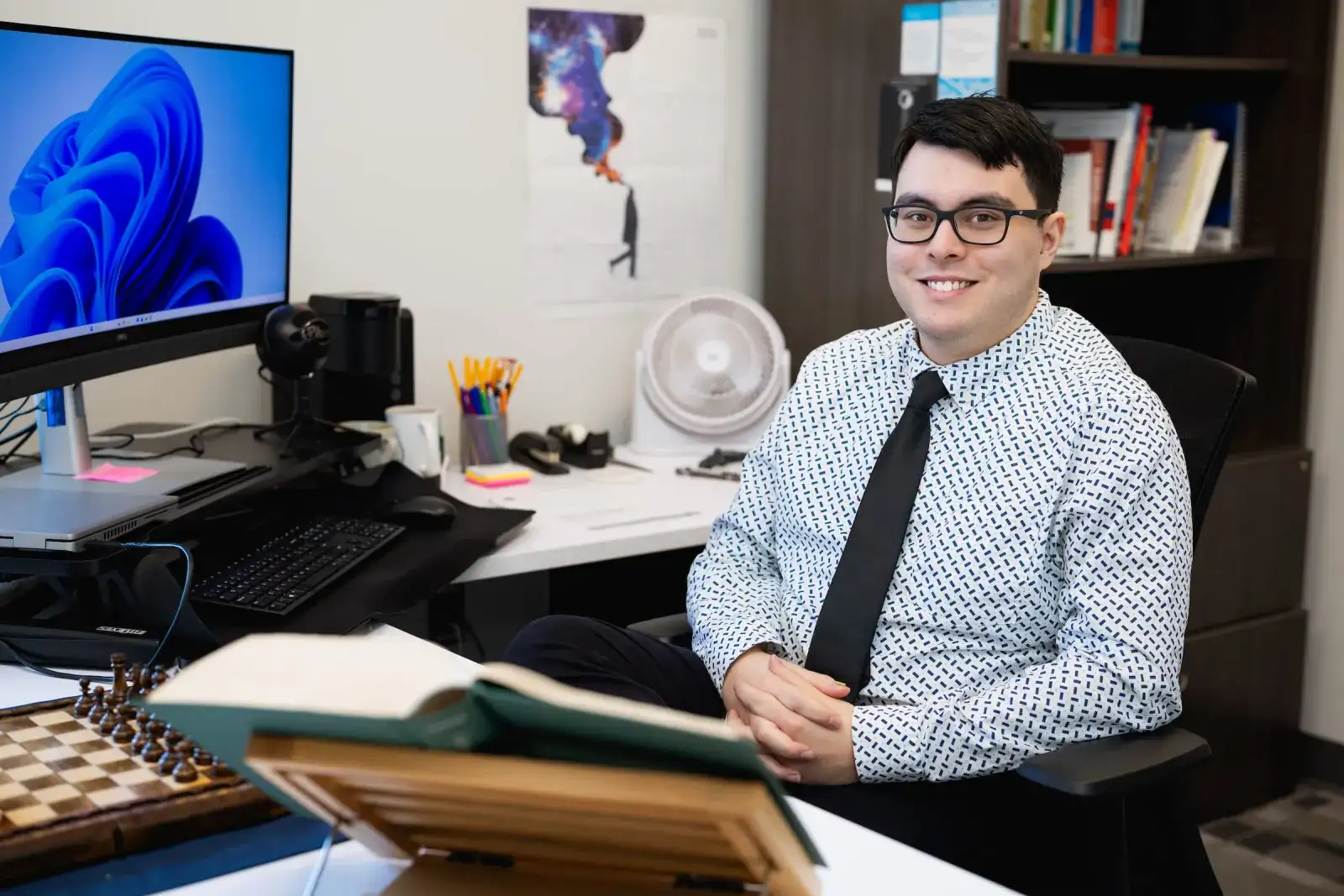 Instructor at a desk in an office lined with books