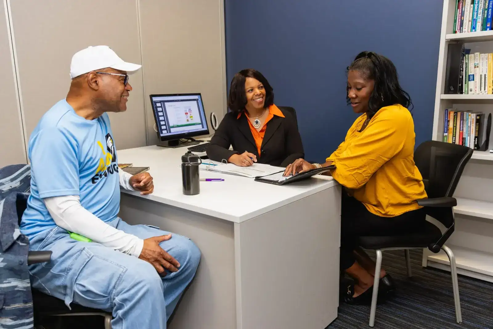 Patient discussing insurance options with two staff members in an office